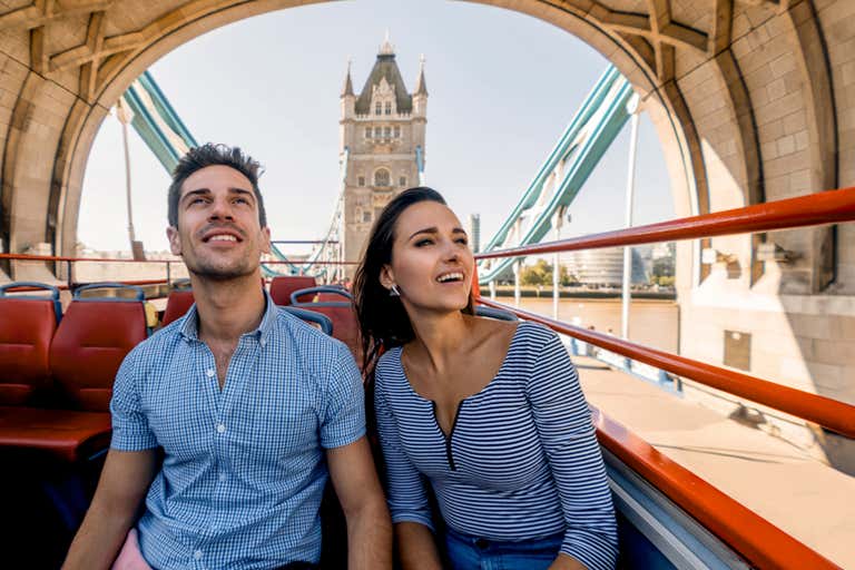 A couple enjoying a bus tour on Tower Bridge in London.