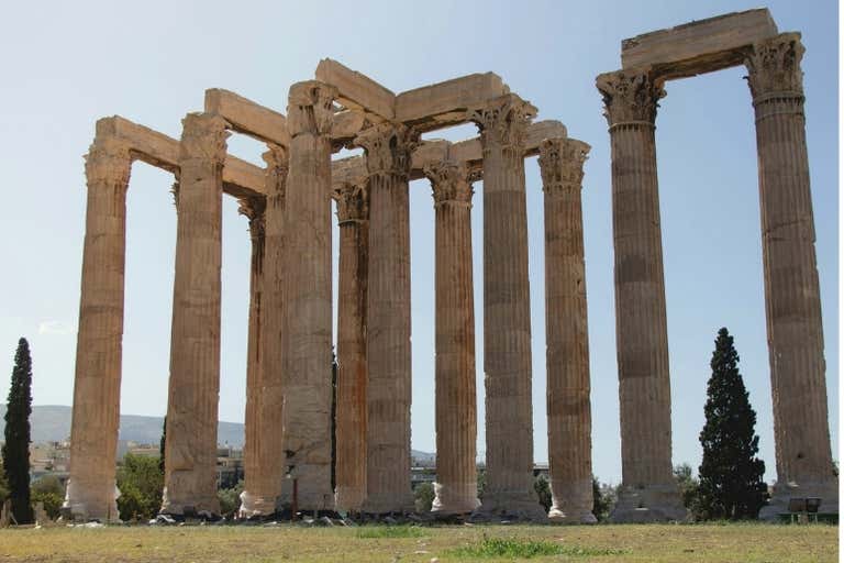 Ancient columns of the Temple of Olympian Zeus in Athens under a clear sky.