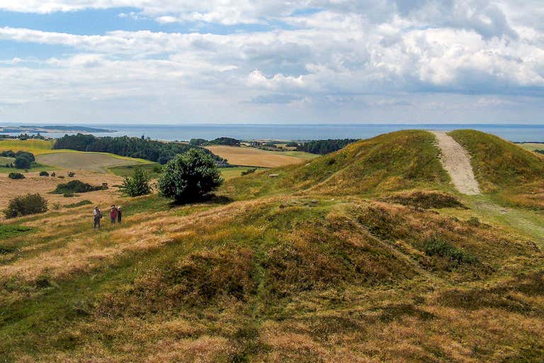 A scenic view of Mols Bjerge National Park with rolling hills and the sea in the background.