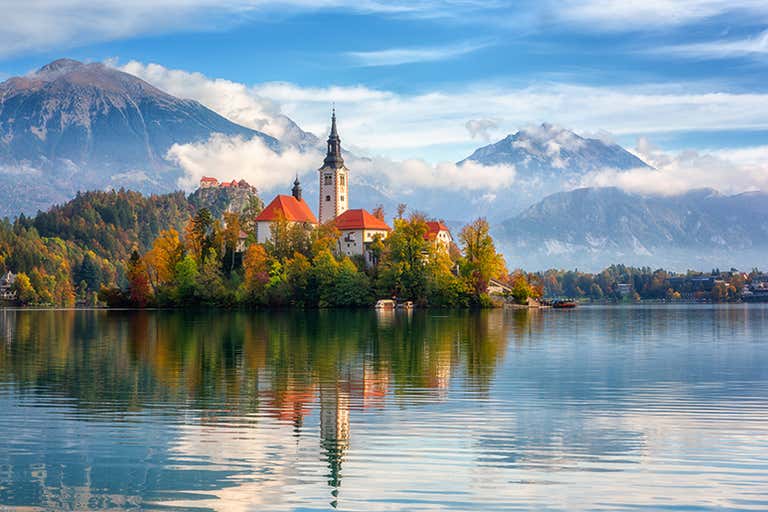 Autumn view of Bled Lake, Slovenia, with a church and castle.