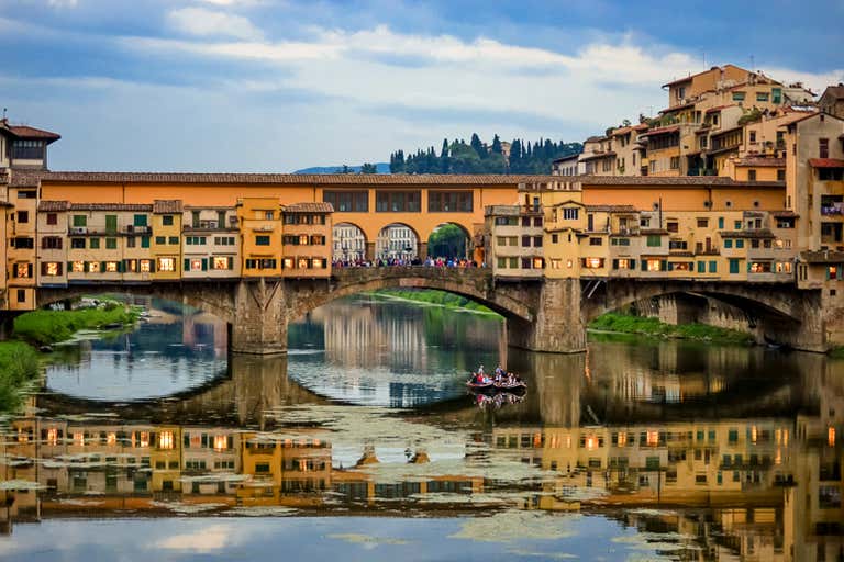 Een schilderachtig uitzicht op de Ponte Vecchio in Florence met weerspiegelingen in de rivier.