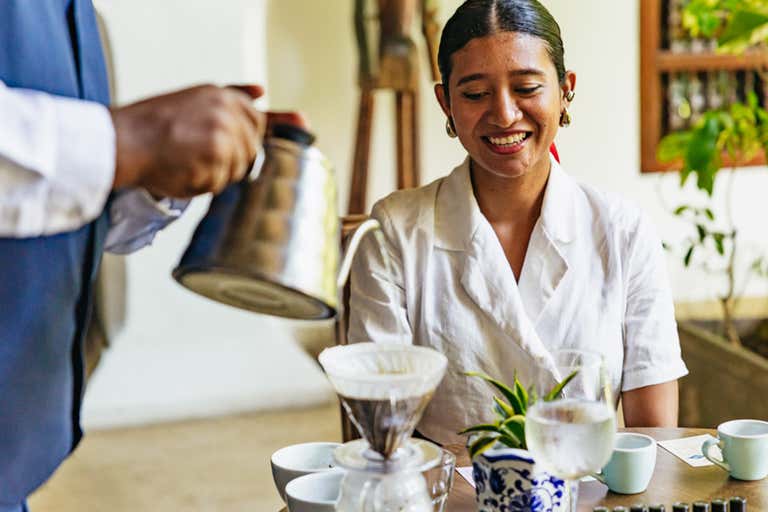 A close-up of a coffee brewing process in Bogotá, featuring a pour-over setup and elegant tableware.
