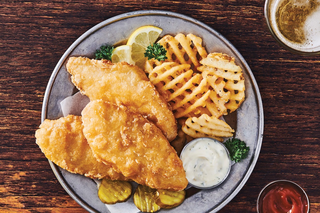 Pubhouse Golden Ale Beer Battered cod presented on a plate with waffle cut fries. 