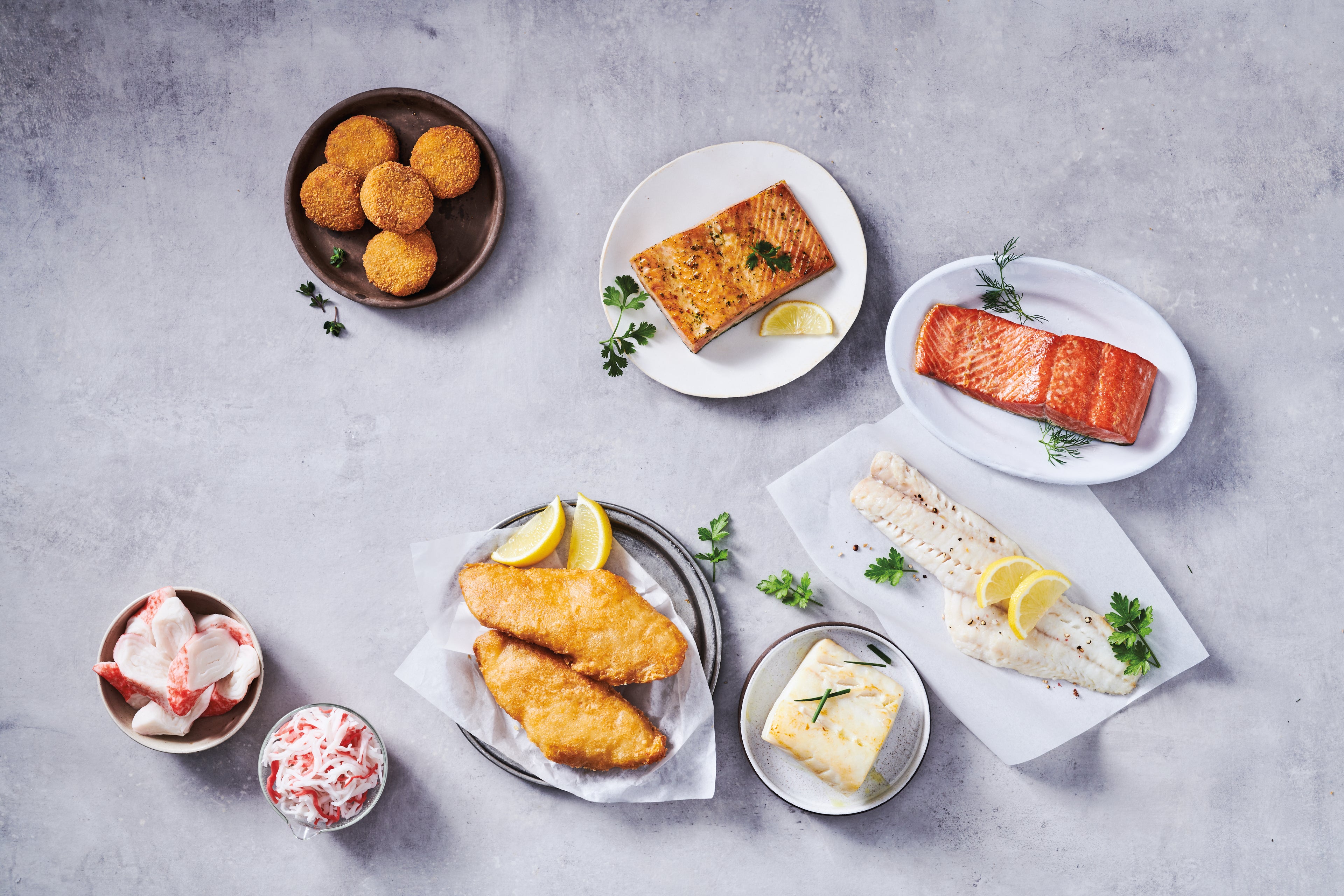 Trident's suite of seafood food service products presented on a marble counter, shot overhead. 