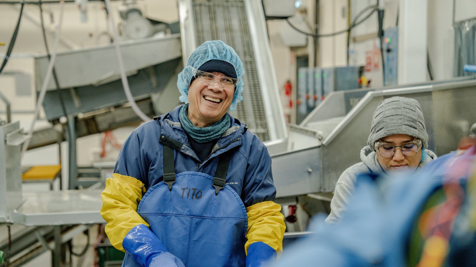 man and woman worker in a fish plant smiling