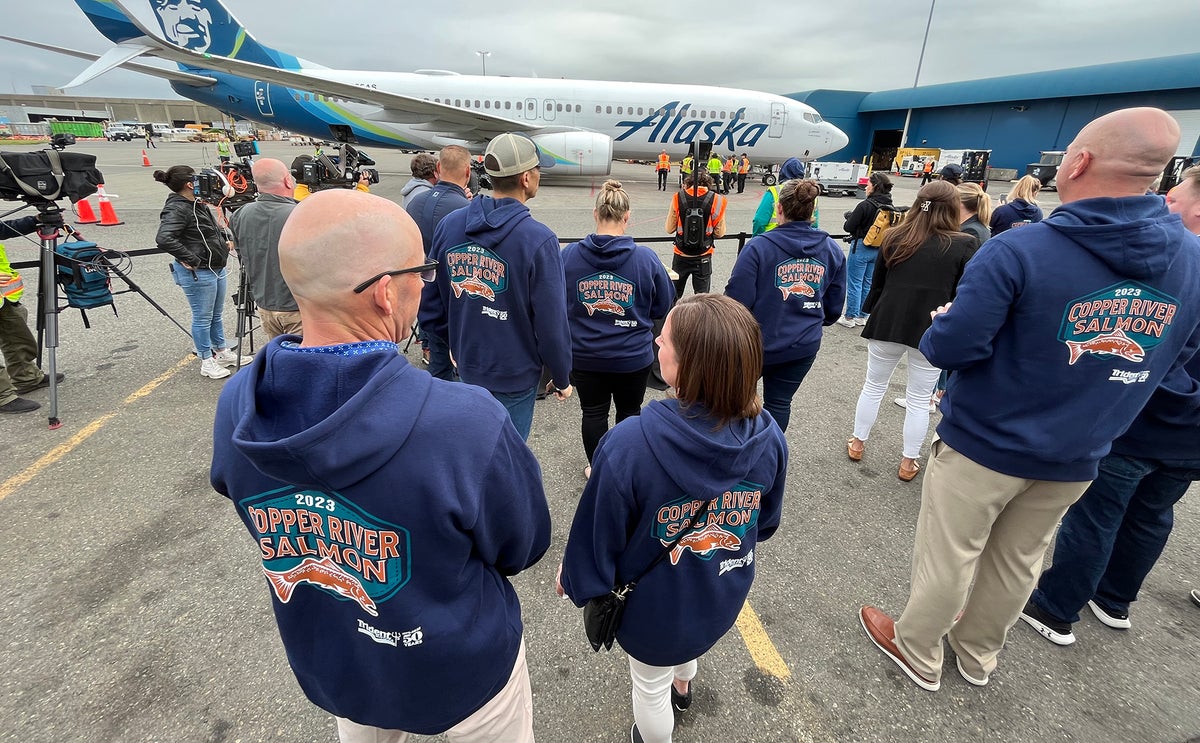 Trident seafoods employees in a group around the first copper river fish of 2023