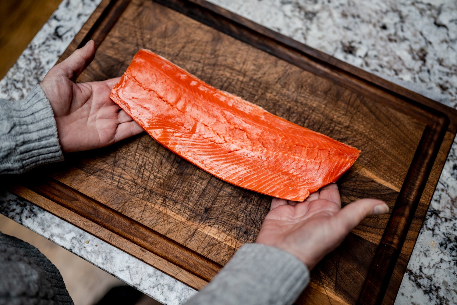 Wild Alaska salmon sits atop a bed of rice in this salmon and sweet potato bowl slide 1