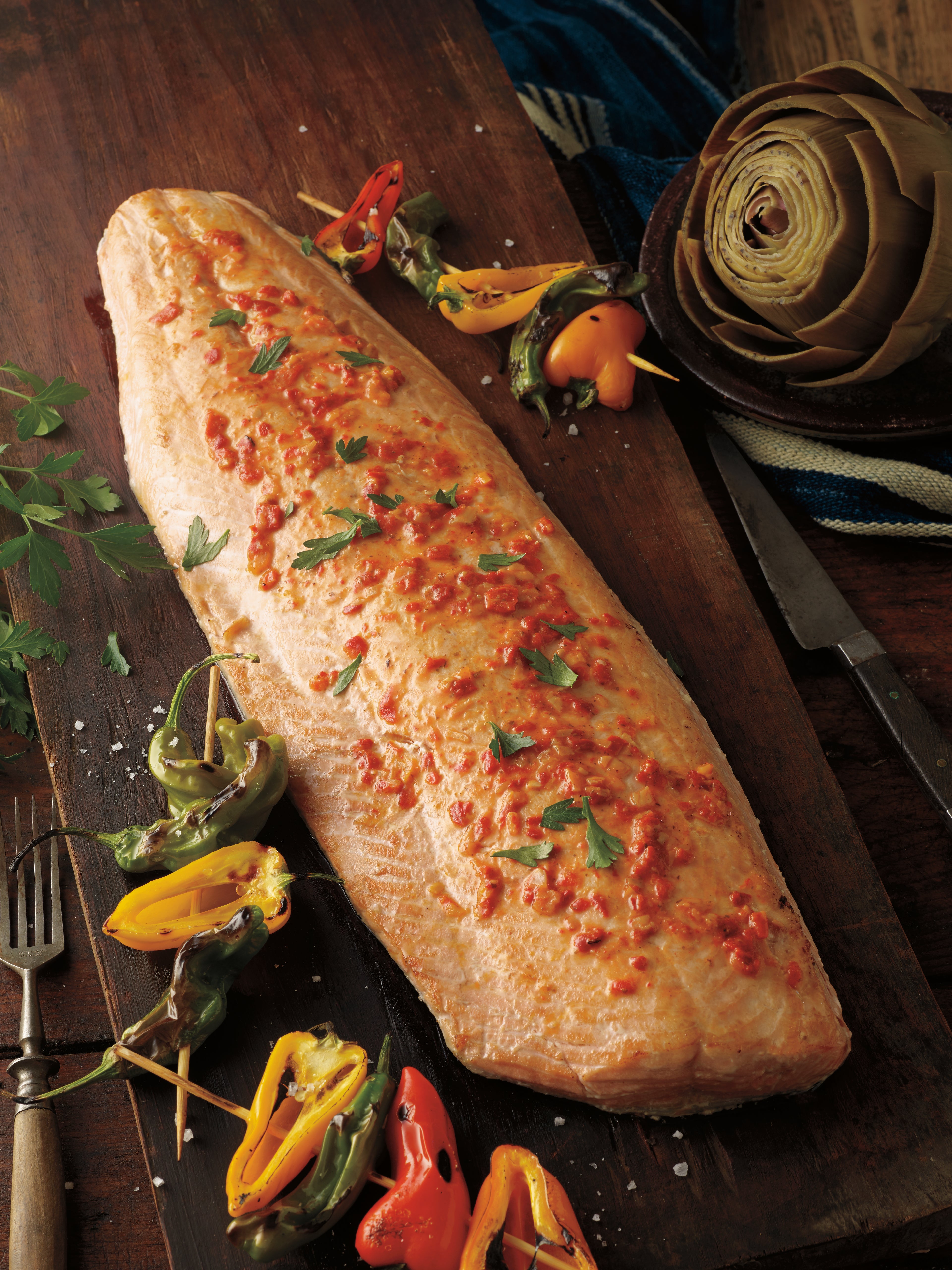 Wild Alaska Keta salmon side, on a board with various accouterments. 