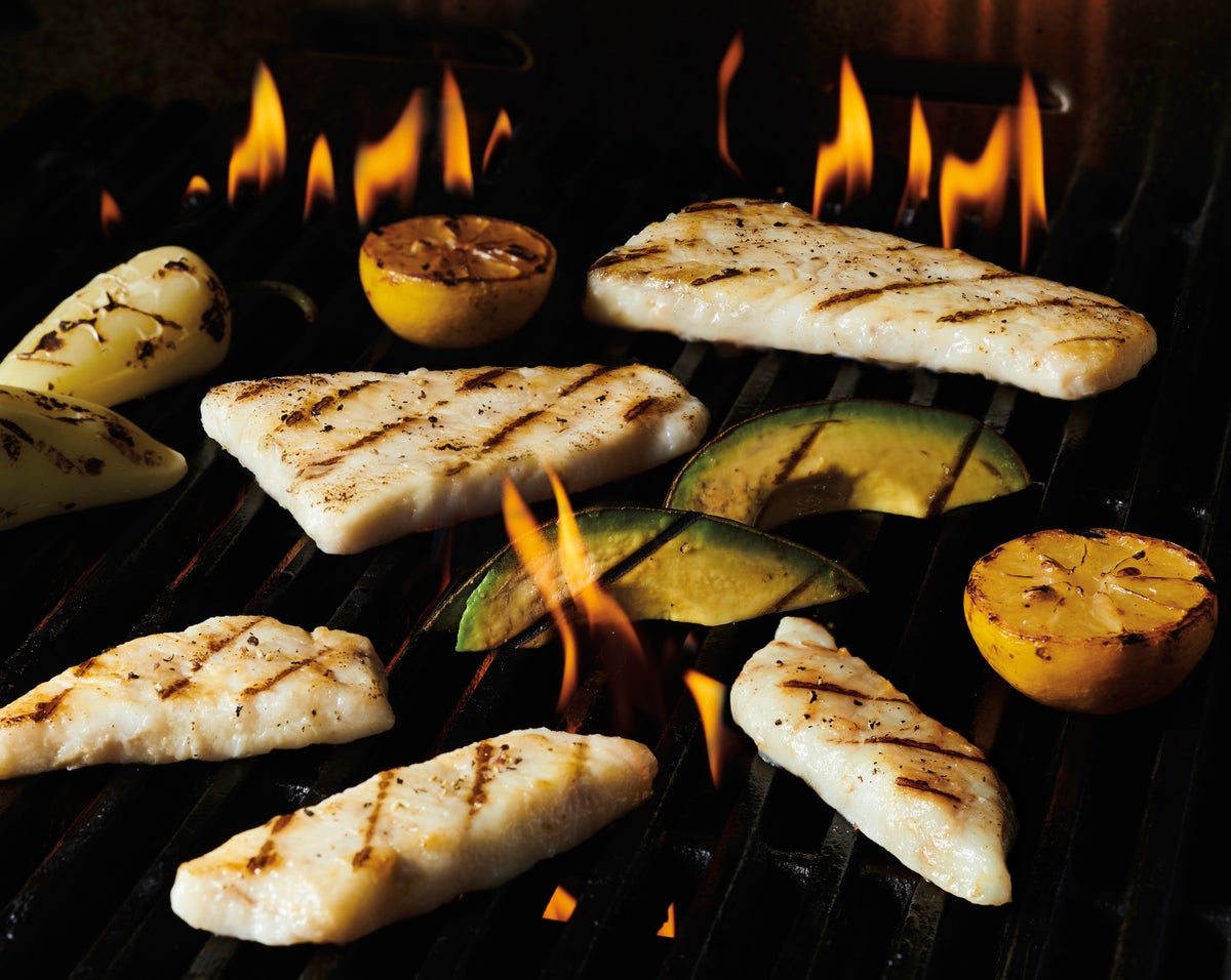 Various Entrée Redi Seafood products on a flaming grill.