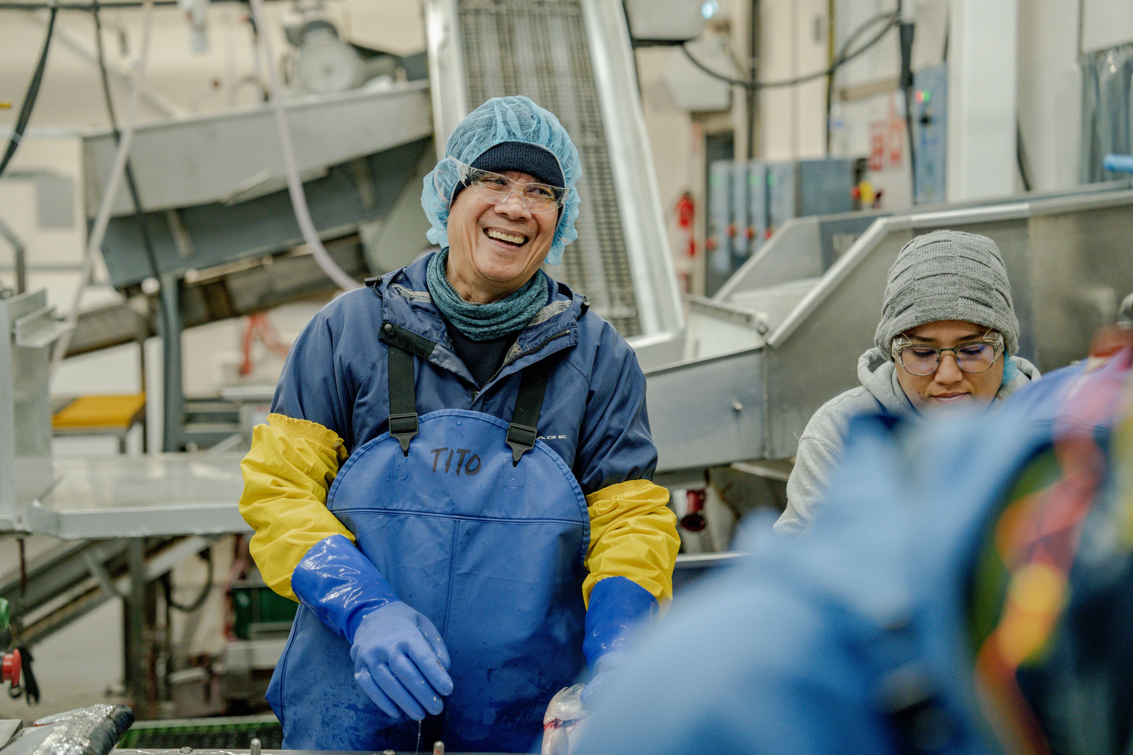 man and woman worker in a fish plant smiling