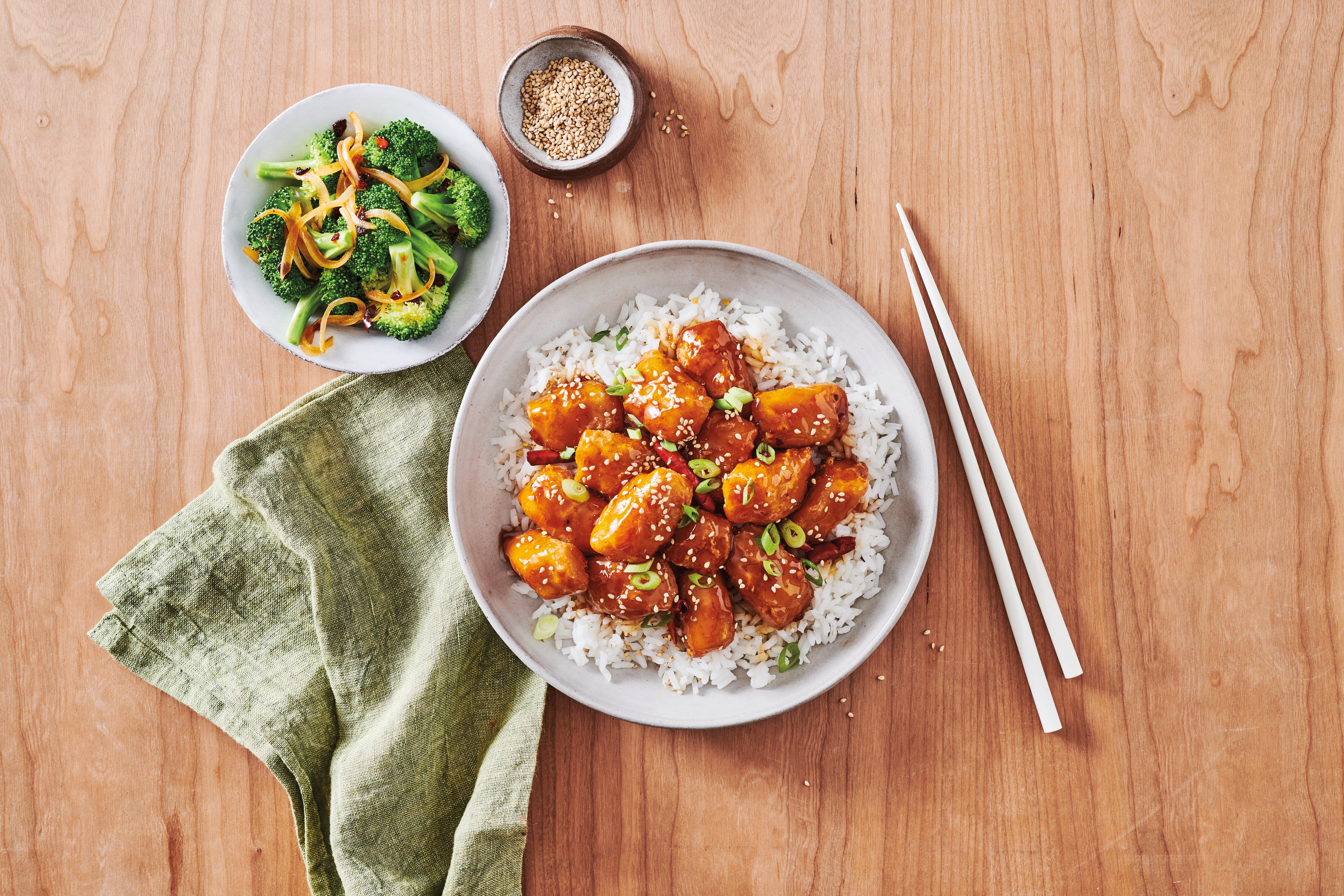 Trident's Crispy Battered Sauceable Nuggets sit atop a bed of white rice, covered in a delicious orange sauce. 