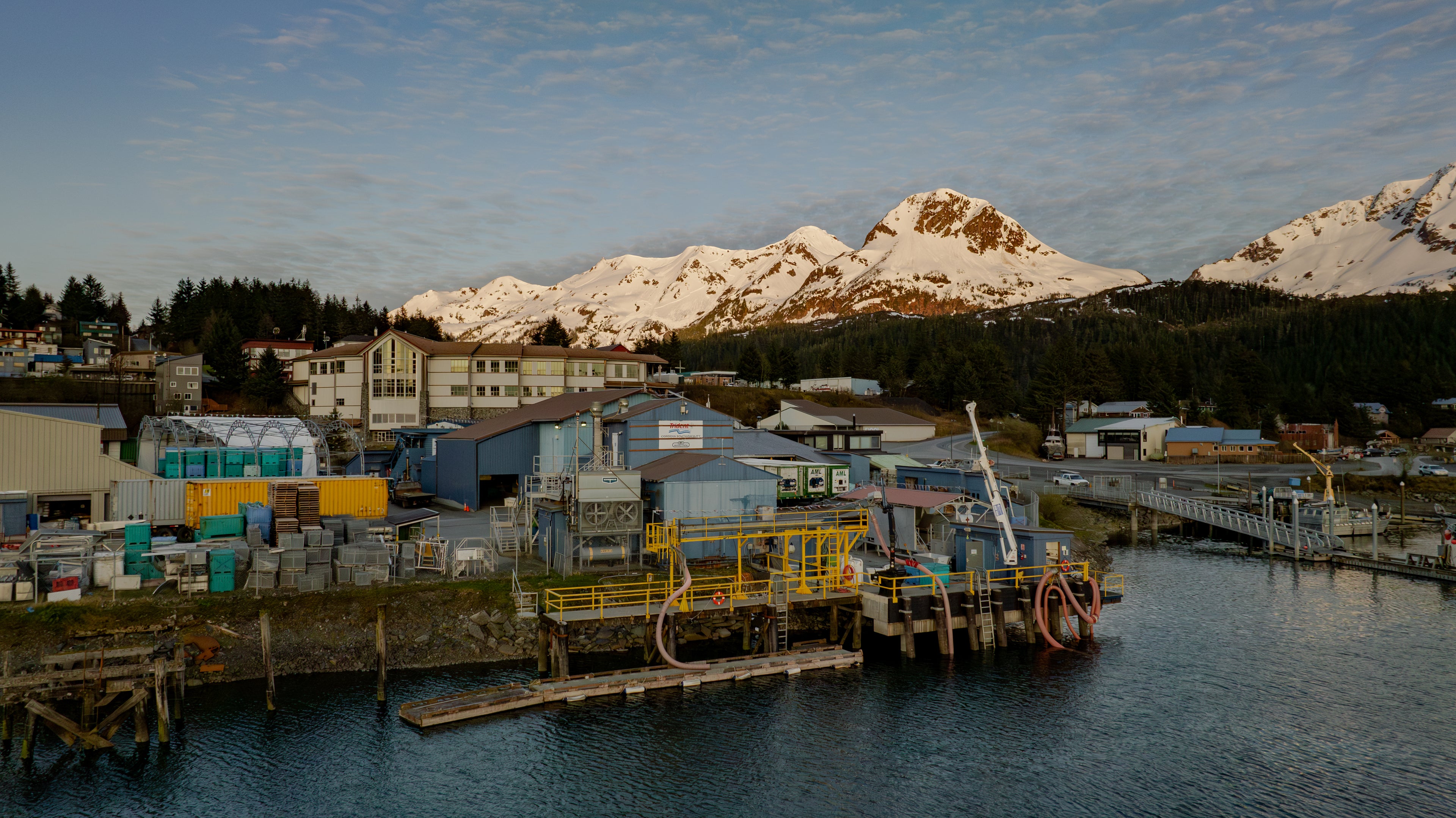 Picture of processing plant in Alaska with mountains in the background