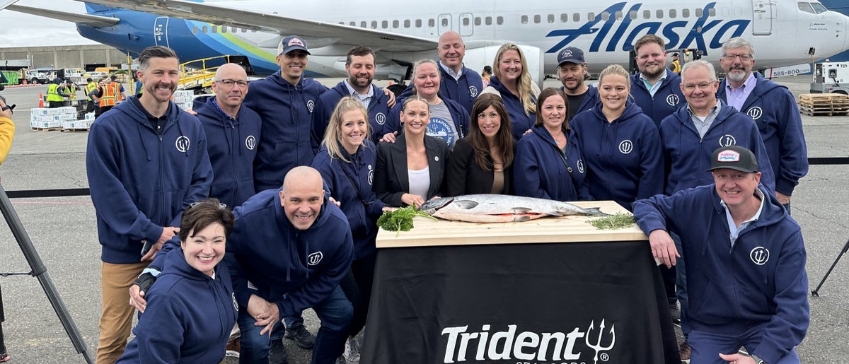 Trident seafoods employees in a group around the first copper river fish of 2023