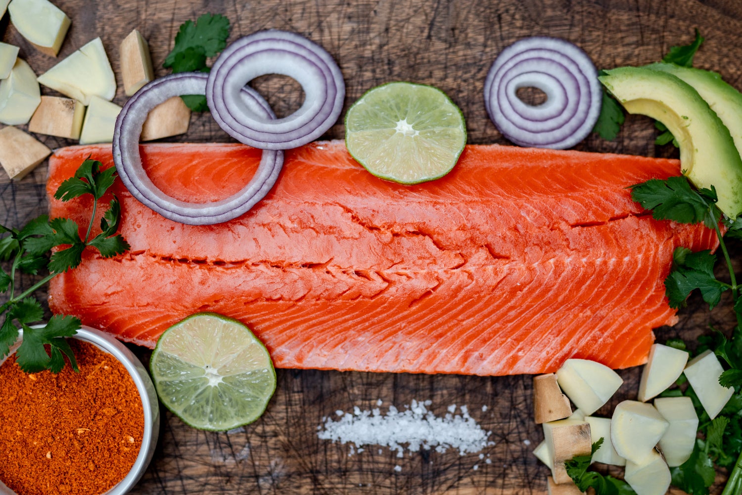 Wild Alaska salmon sits atop a bed of rice in this salmon and sweet potato bowl slide 2