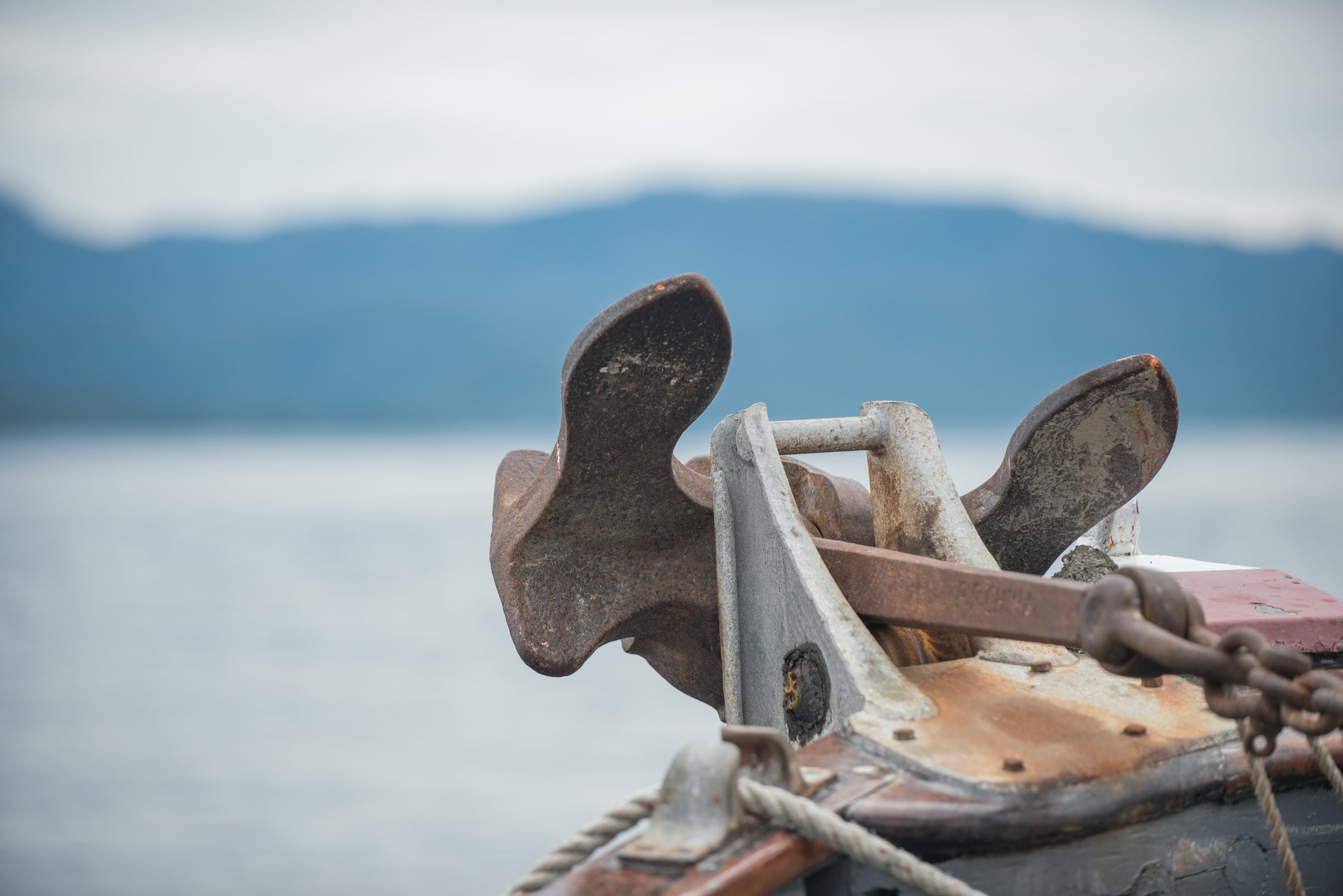 Anchor on the front of a boat with mountain in the background