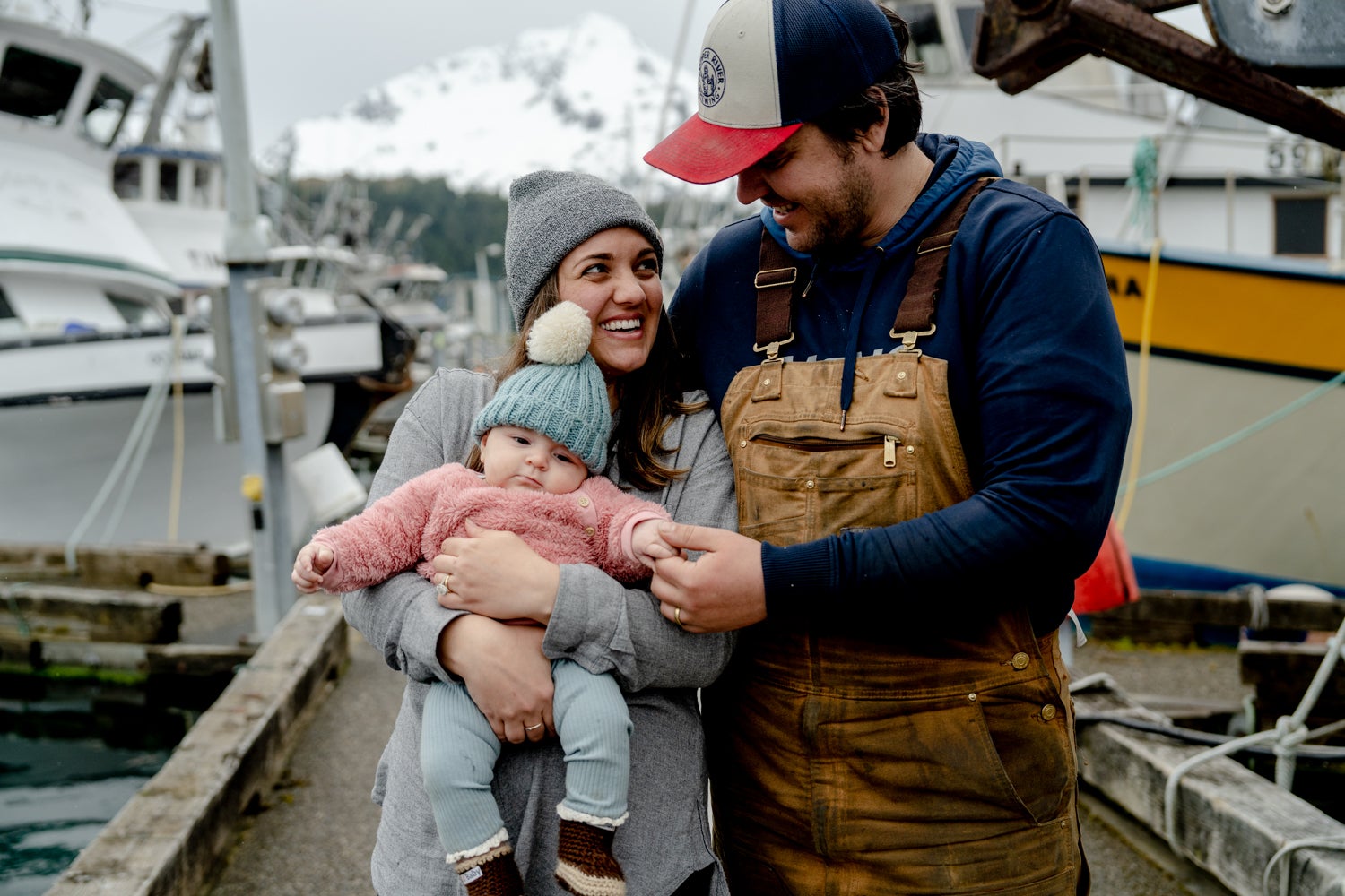 Kinsey and Zeke Brown holding their daughter, Odette, on the dock in Cordova, AK.