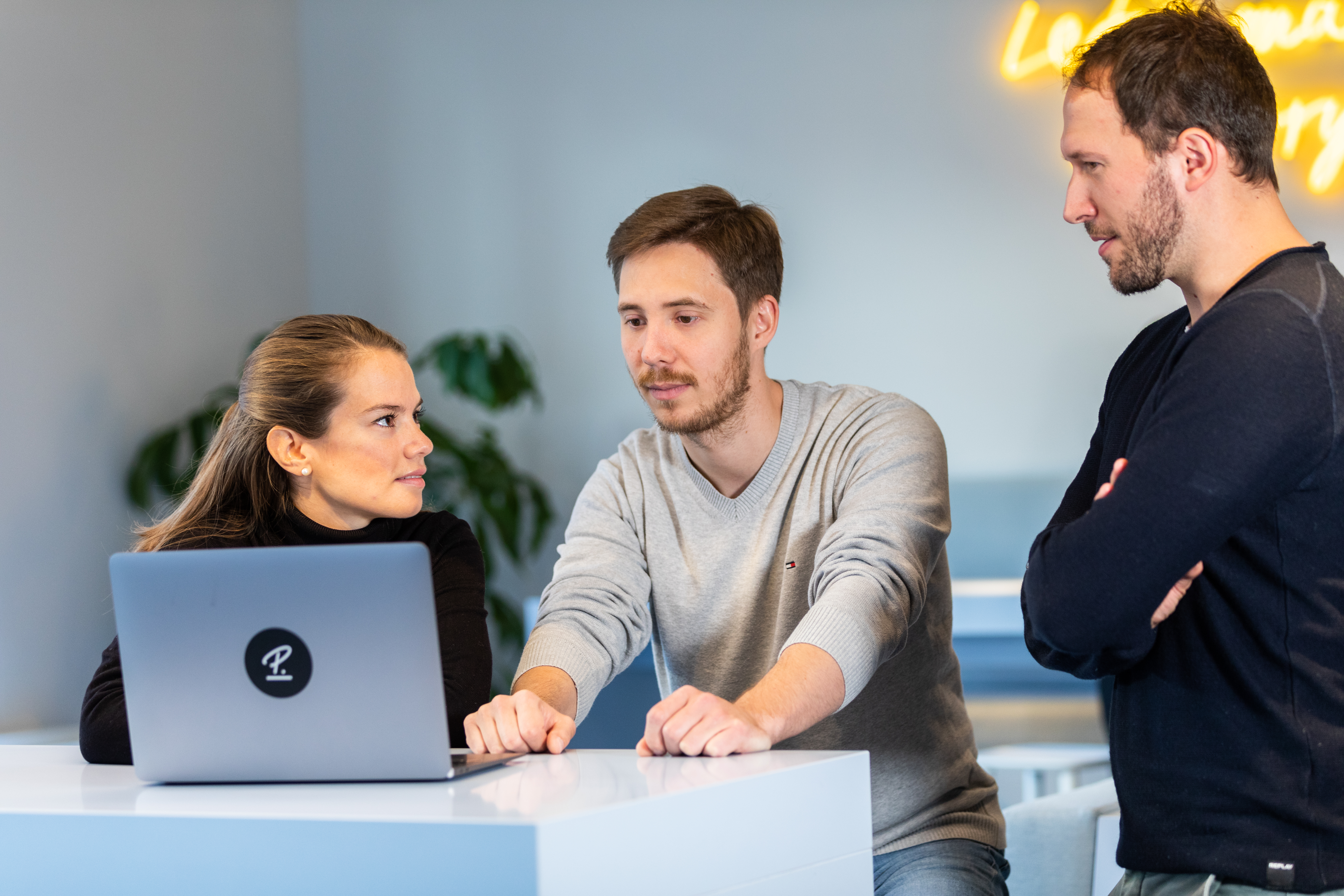 Three people looking at the laptop