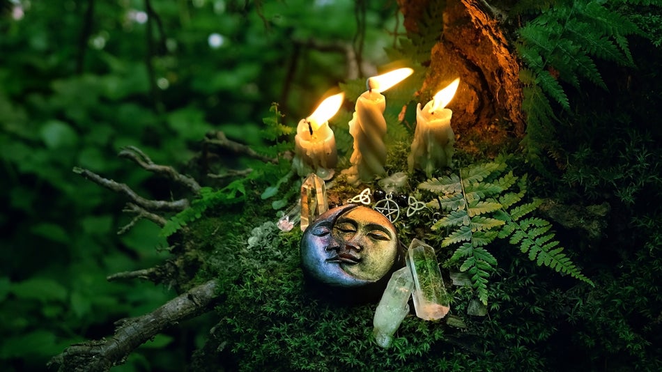a forest ritual with candle lights, crystals