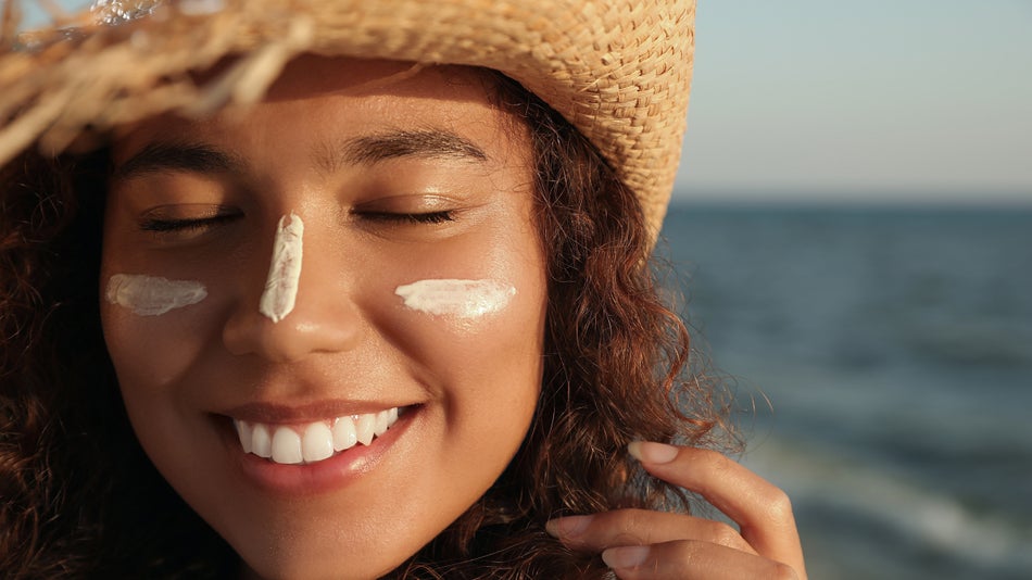 smiling woman at the beach with lotion on her face