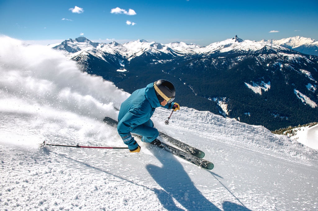 Whistler Blackcomb_Skier on Groomed Slope_Peaks Panorama_(c): Whistler Blackcomb