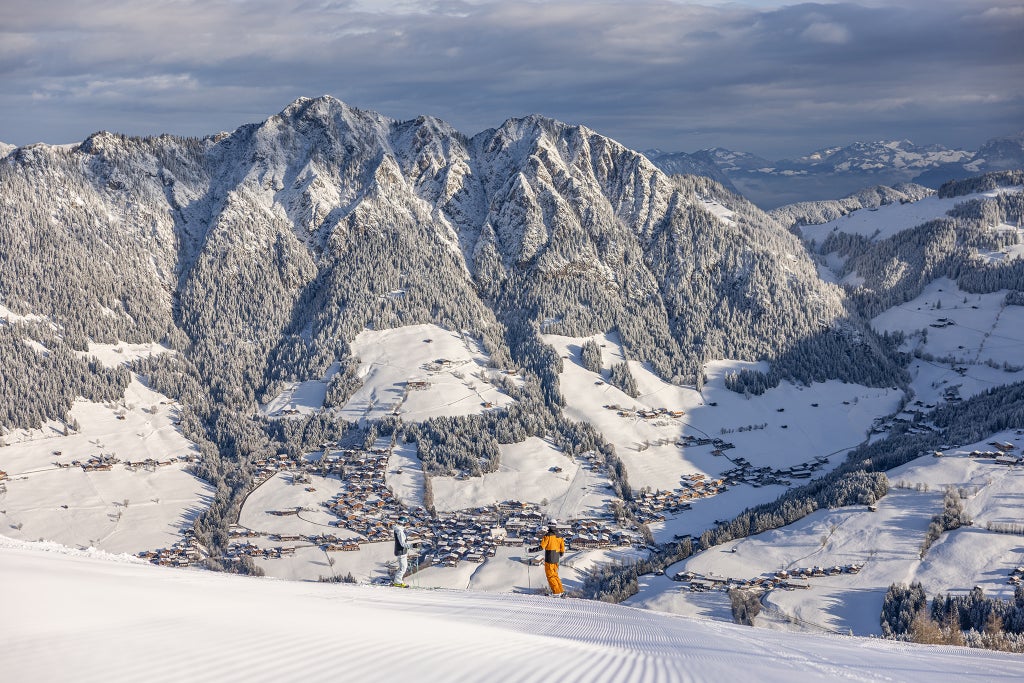Alpbach_Skiers Overlooking Village_(c): Alpbachtal Tourismus / Shootandstyle