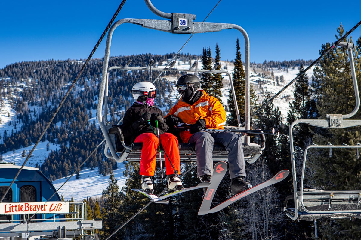 Two people chatting on chairlift on a sunny day