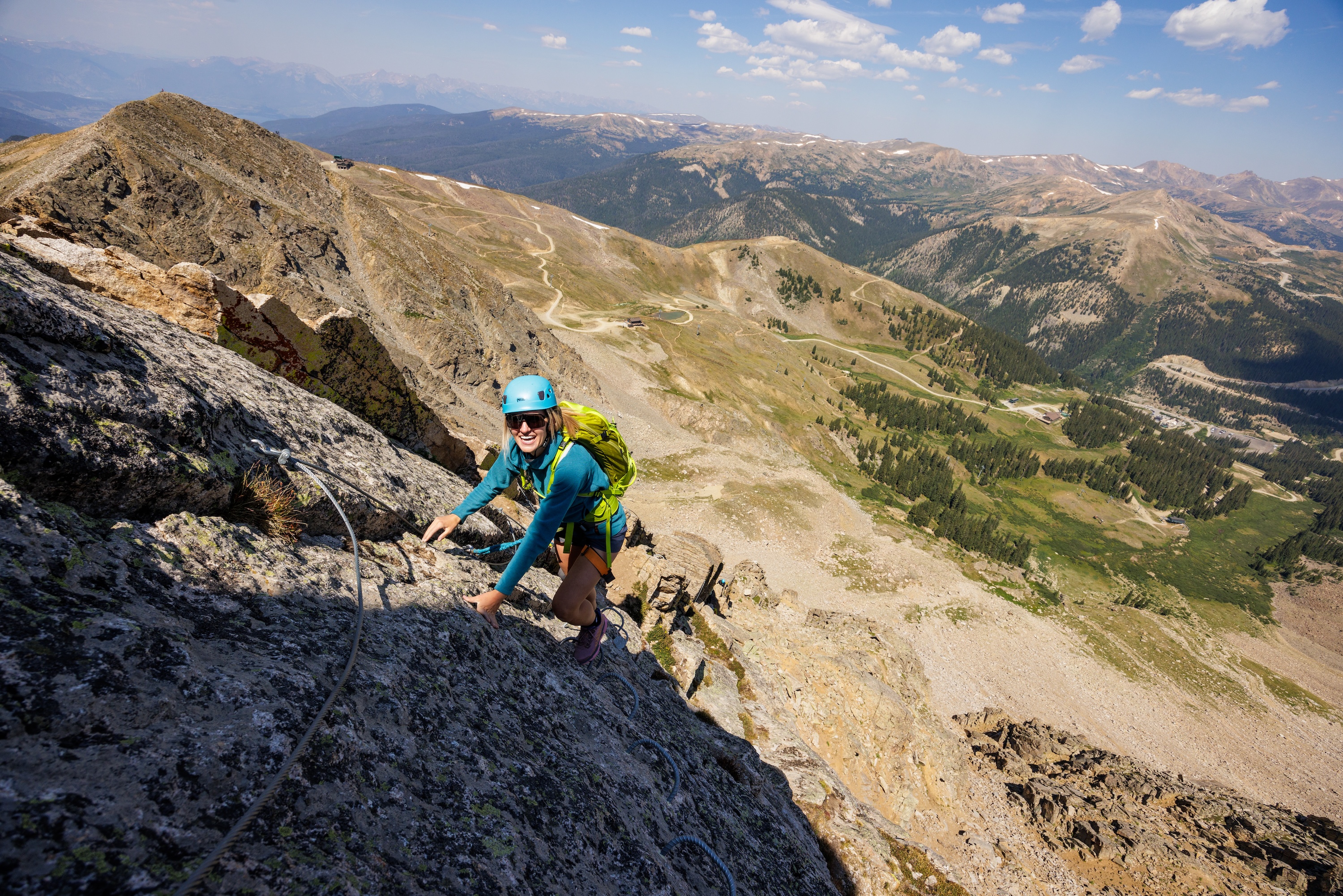 Woman smiling while climbing Via Ferrata at Arapahoe Basin Ski Resort