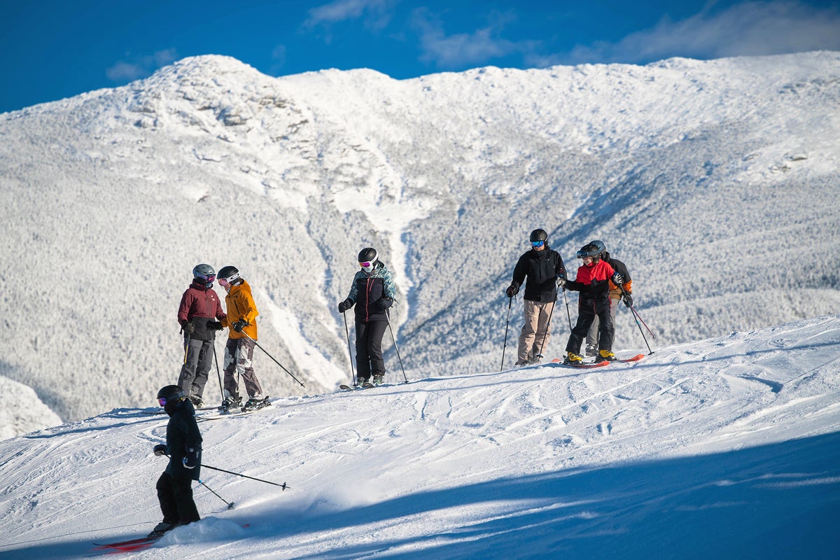 Cannon Mountain bluebird day with group of friends taking a break on slopes.