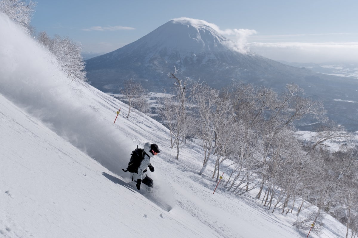 Snowboarding through powder on a sunny day in Japan