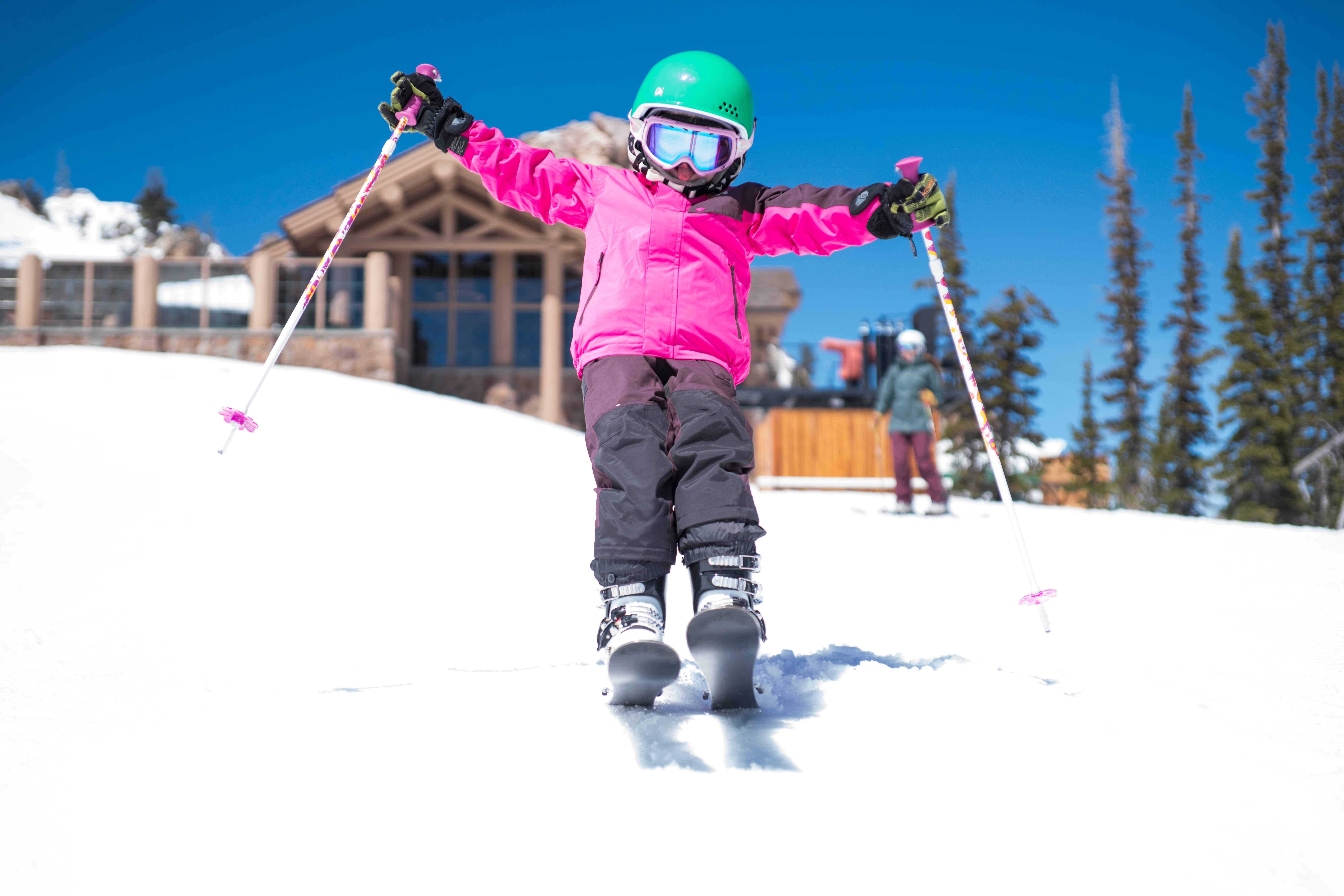Kid learning to ski on a sunny day