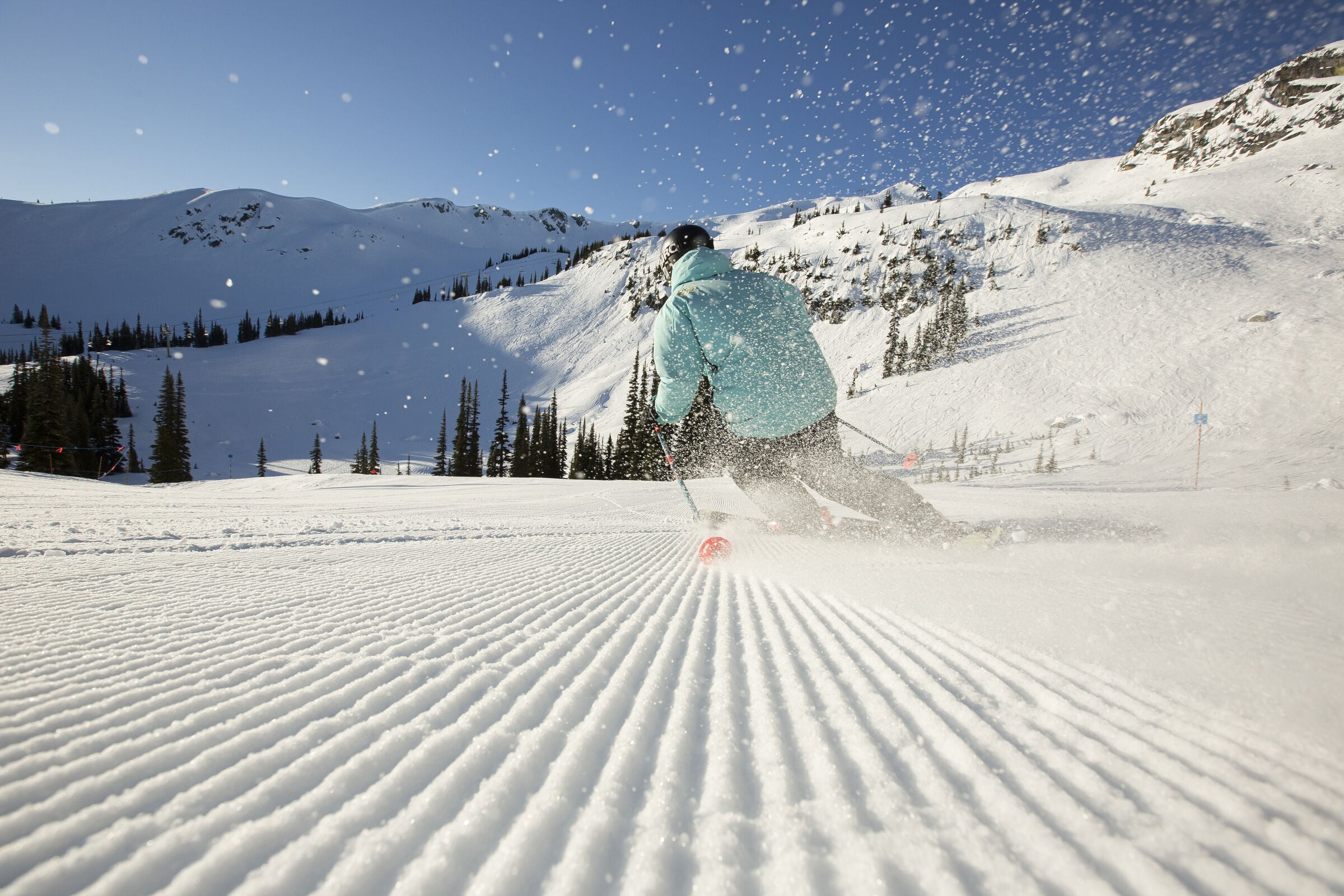 Skiing down perfectly groomed run on a clear day at a ski resort