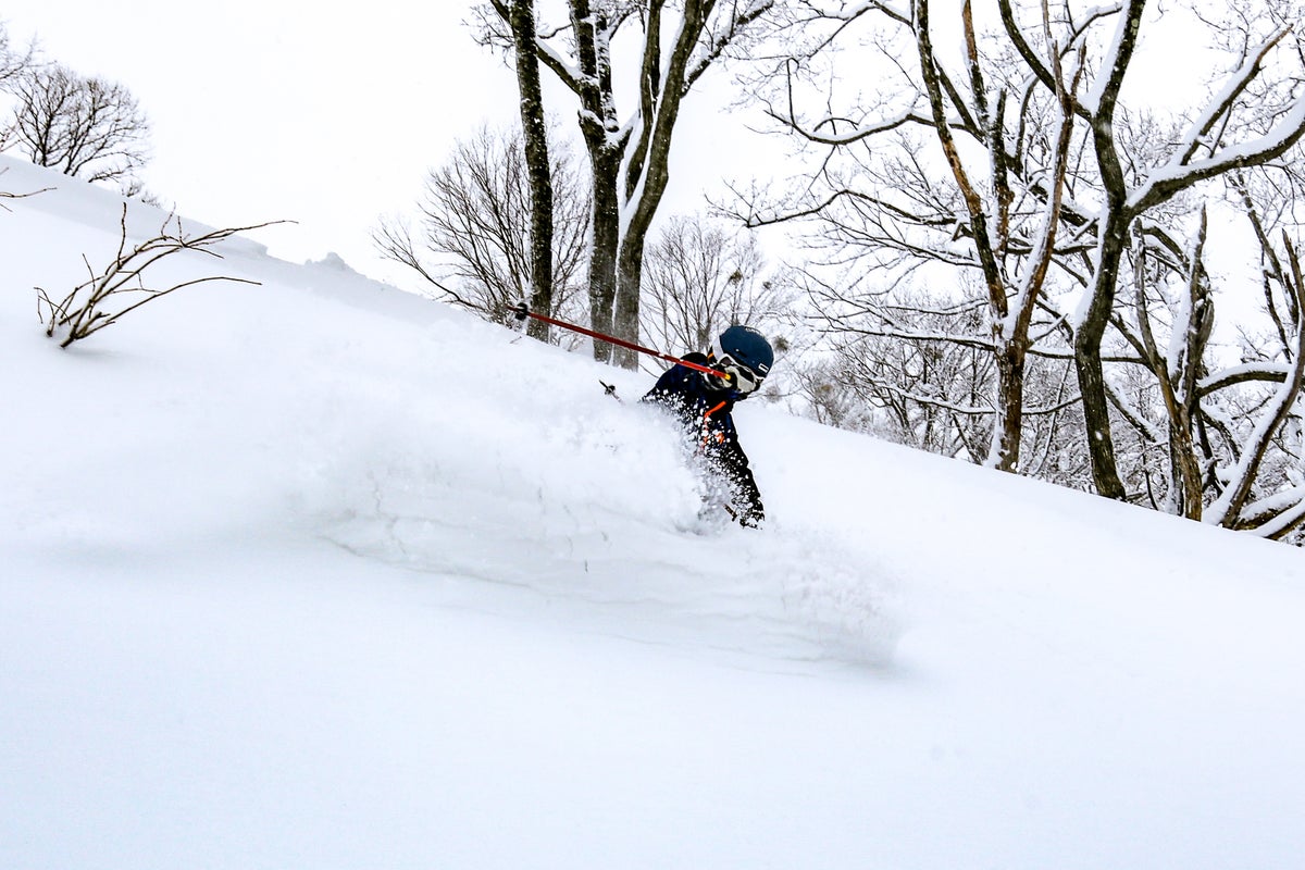 Skiing down slopes in Japan through powder