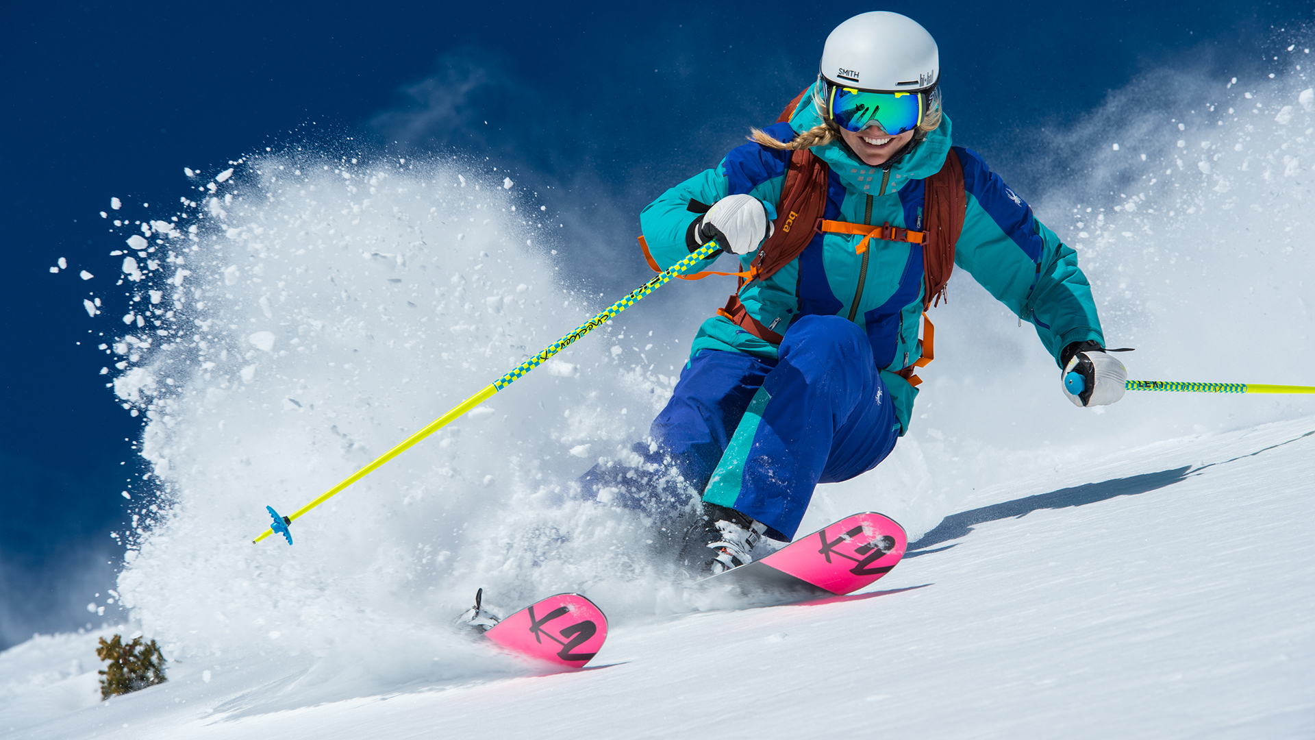 Woman skiing through powder on a sunny day