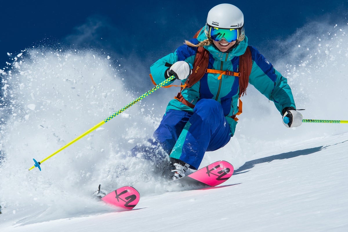 Woman skiing through powder on a sunny day