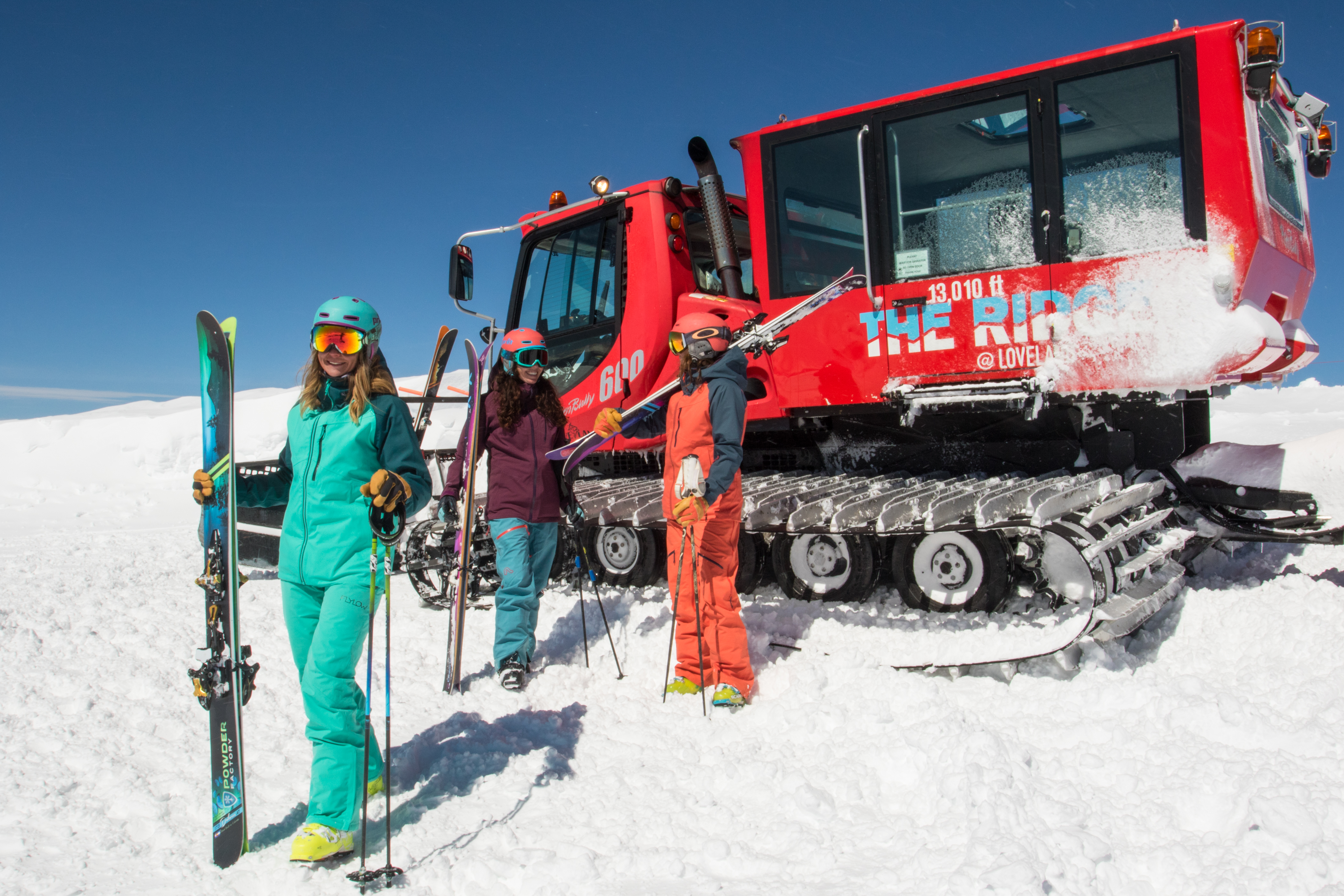 Group of friends getting off snow cat at Loveland on a sunny day