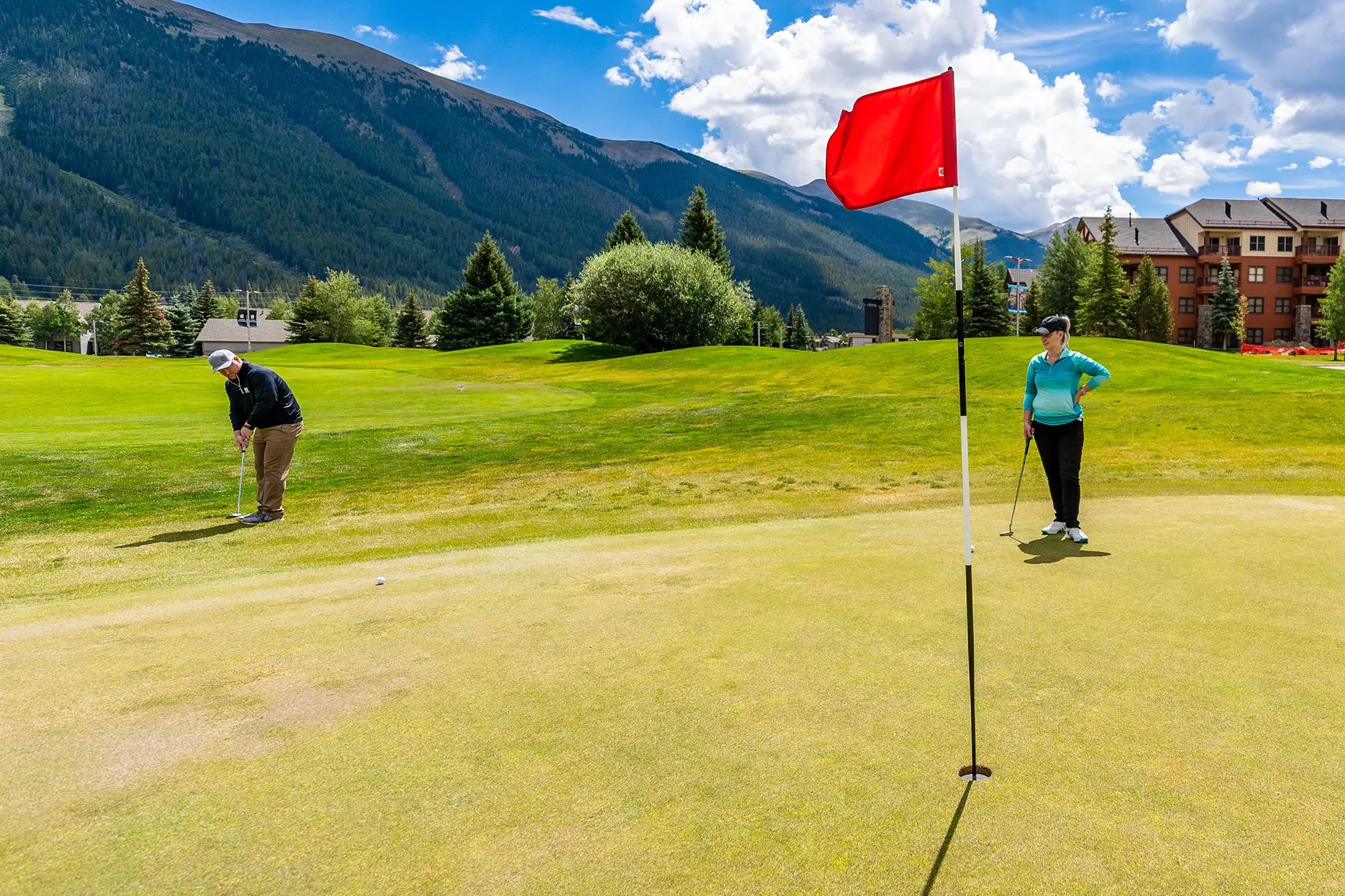 Two people golfing on partly cloudy day at Copper Creek Golf Course Copper Mountain