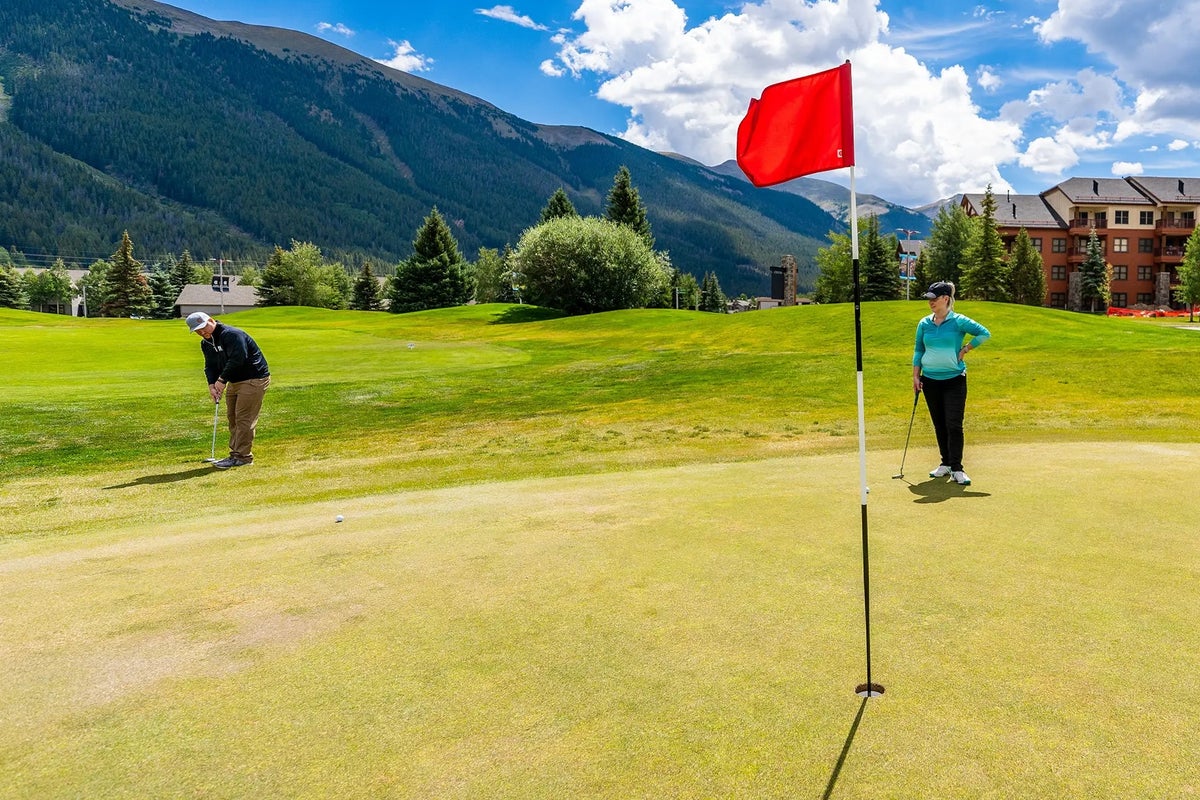 Two people golfing on partly cloudy day at Copper Creek Golf Course Copper Mountain
