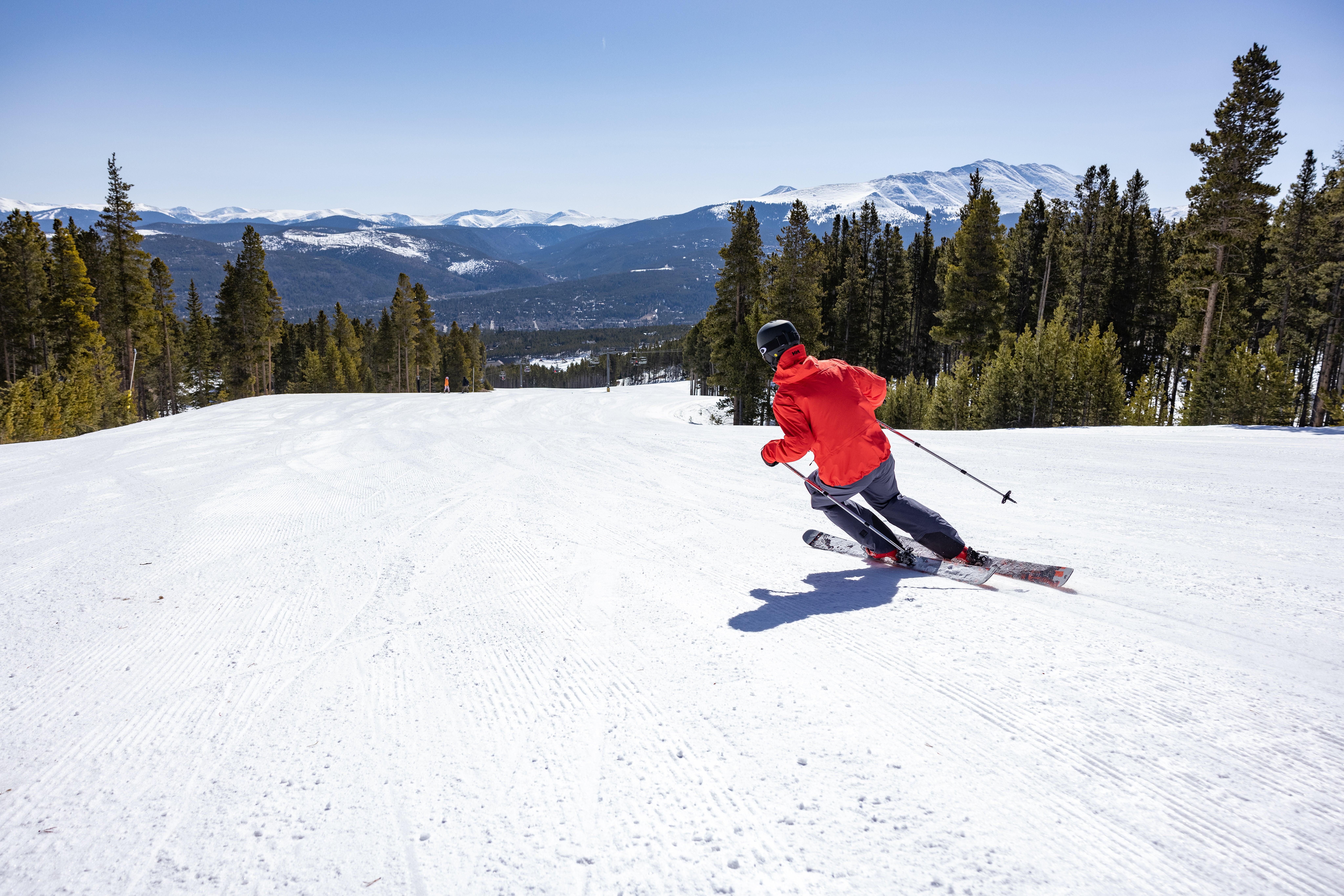 Skiing down a groomed run on a sunny day