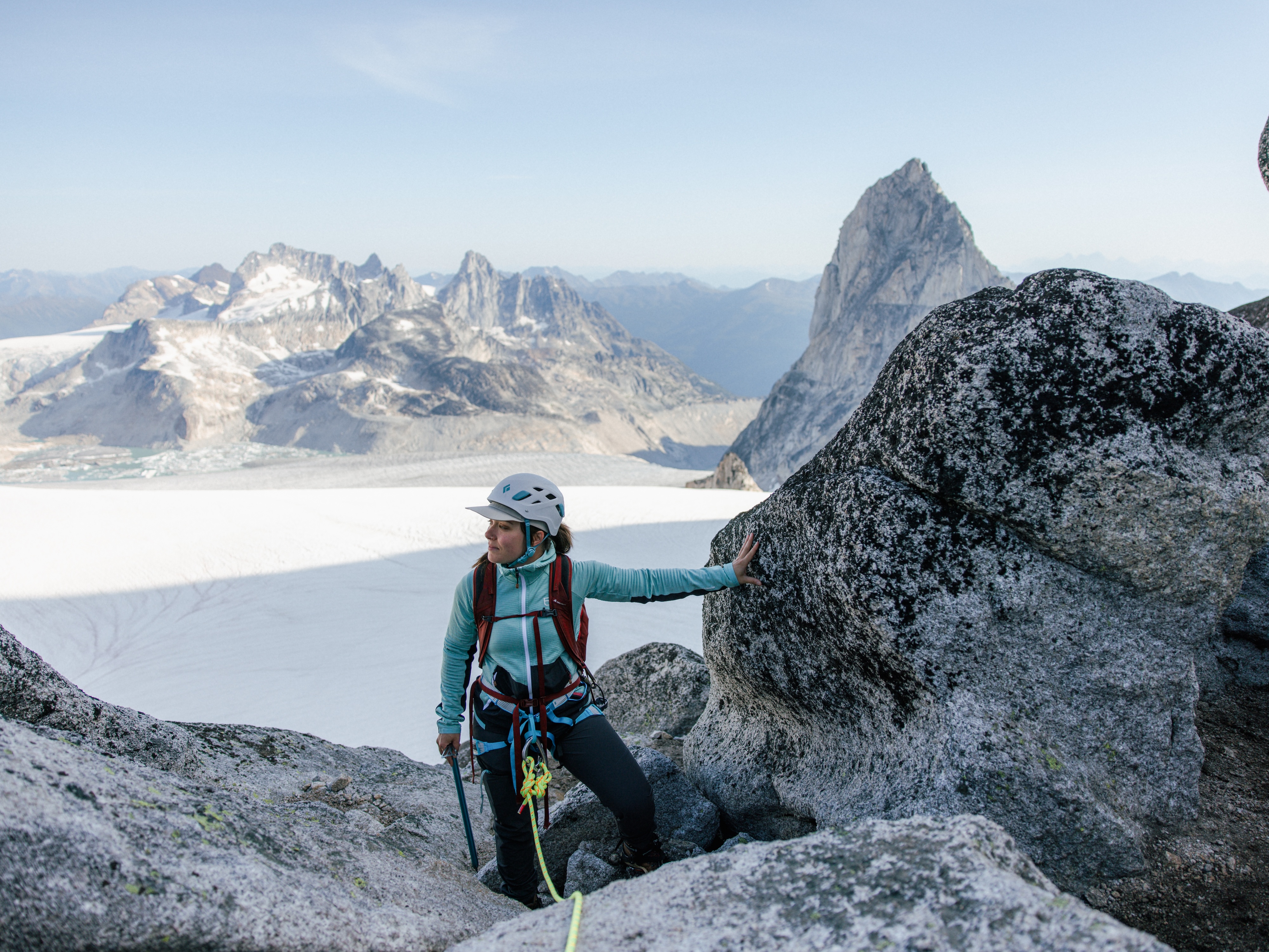 Woman taking break on via ferrata atop peak above icefield