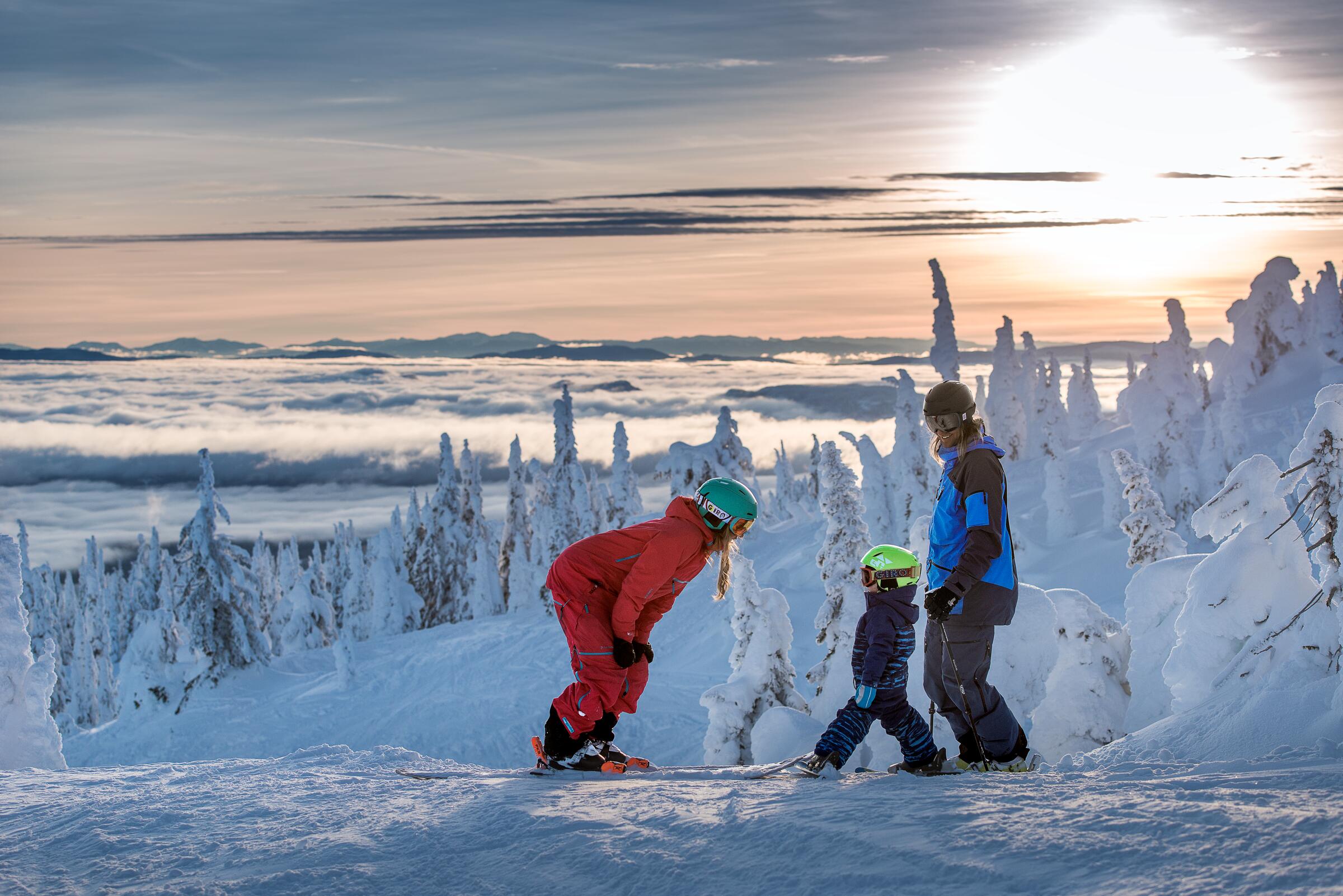 Ski instructor teaching kid how to ski on ski slopes