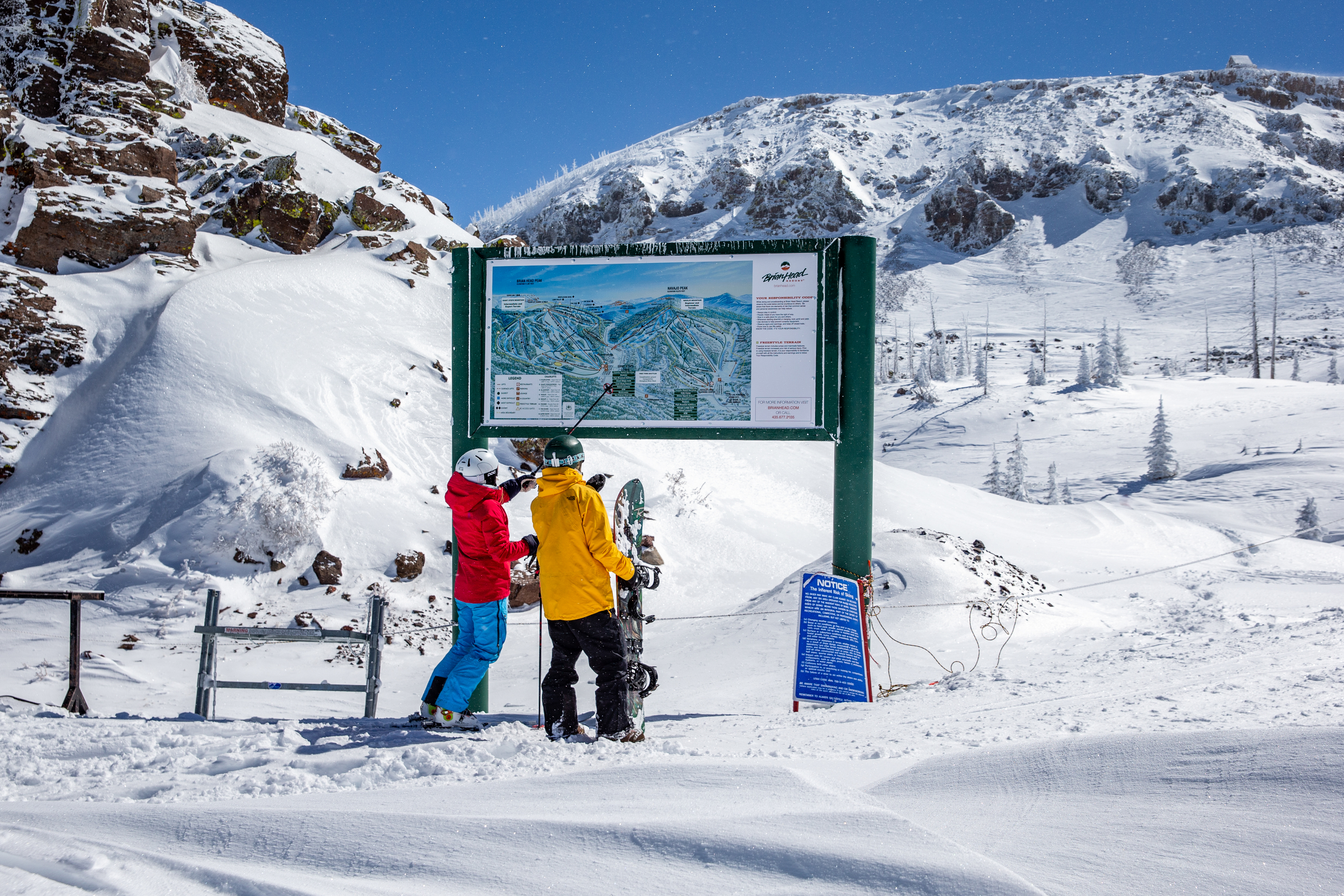 Ski couple reading trail map, Brian Head, Utah.