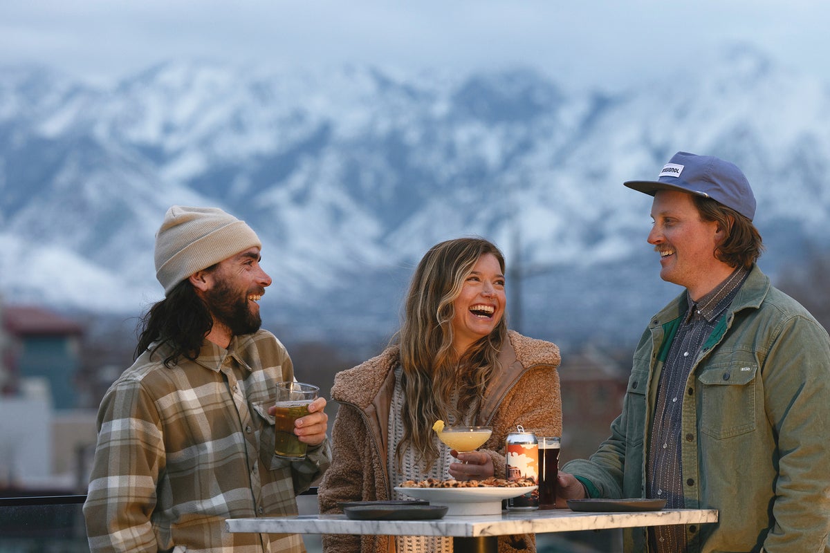Group of friends laughing while enjoying drinks together