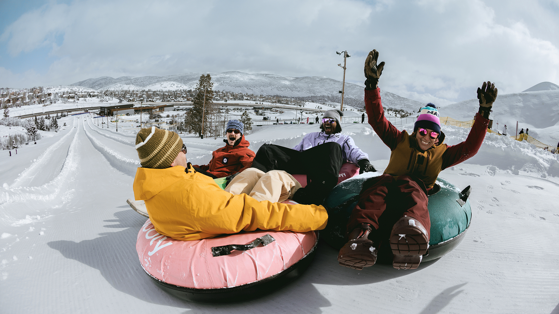 Group of friends smiling while tubing down a tubing lane.