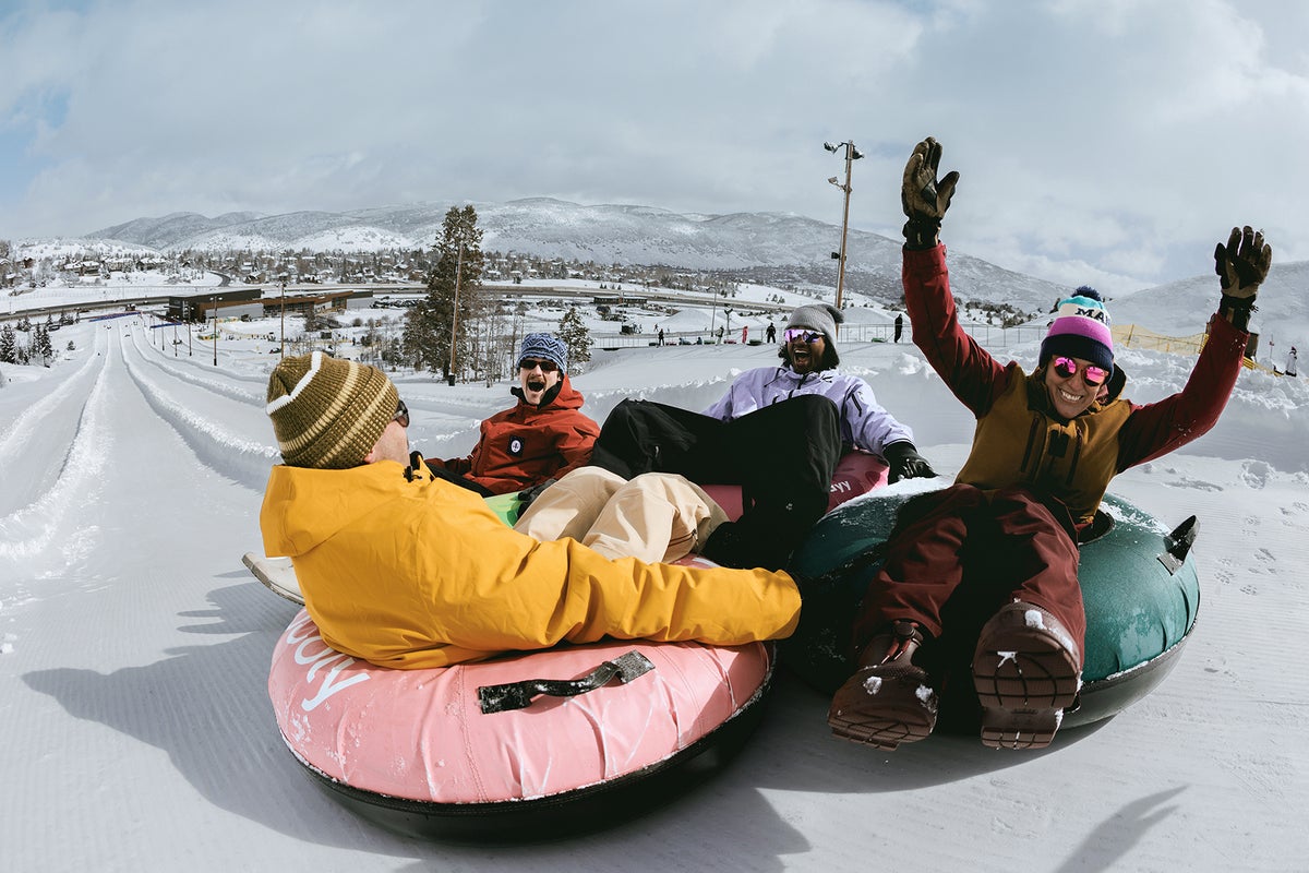 Group of friends smiling while tubing down a tubing lane.