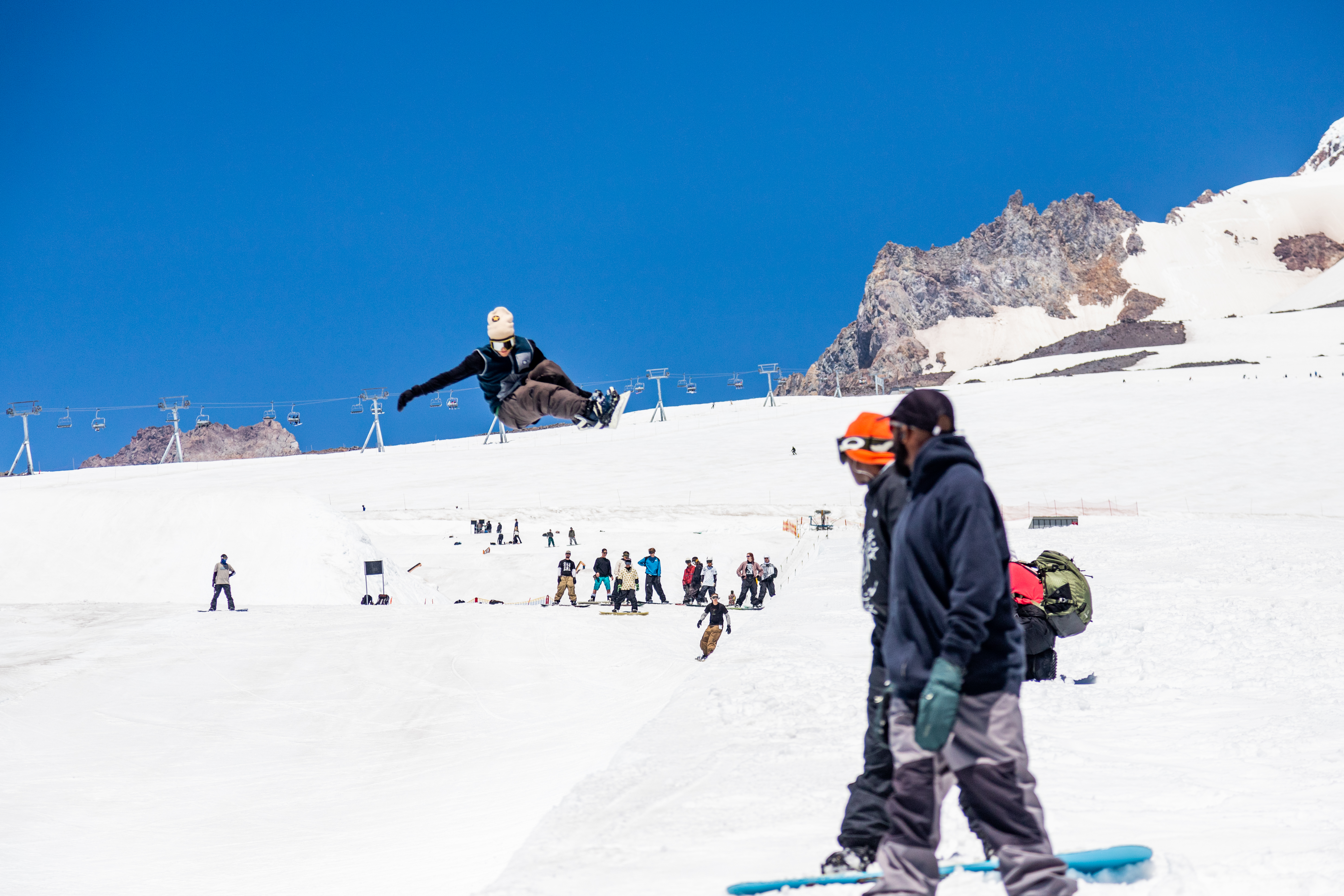 Snowboarder getting air at Timberline terrain park on a summer day