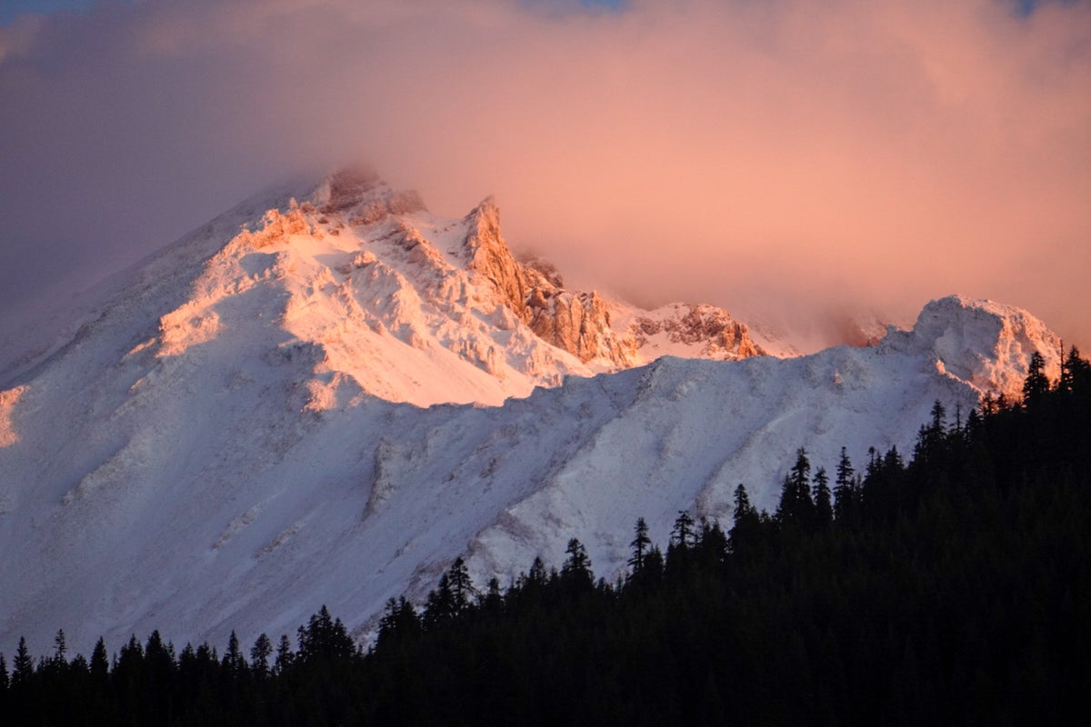 Fog and clouds linger over the top of snow-covered Mt. Shasta