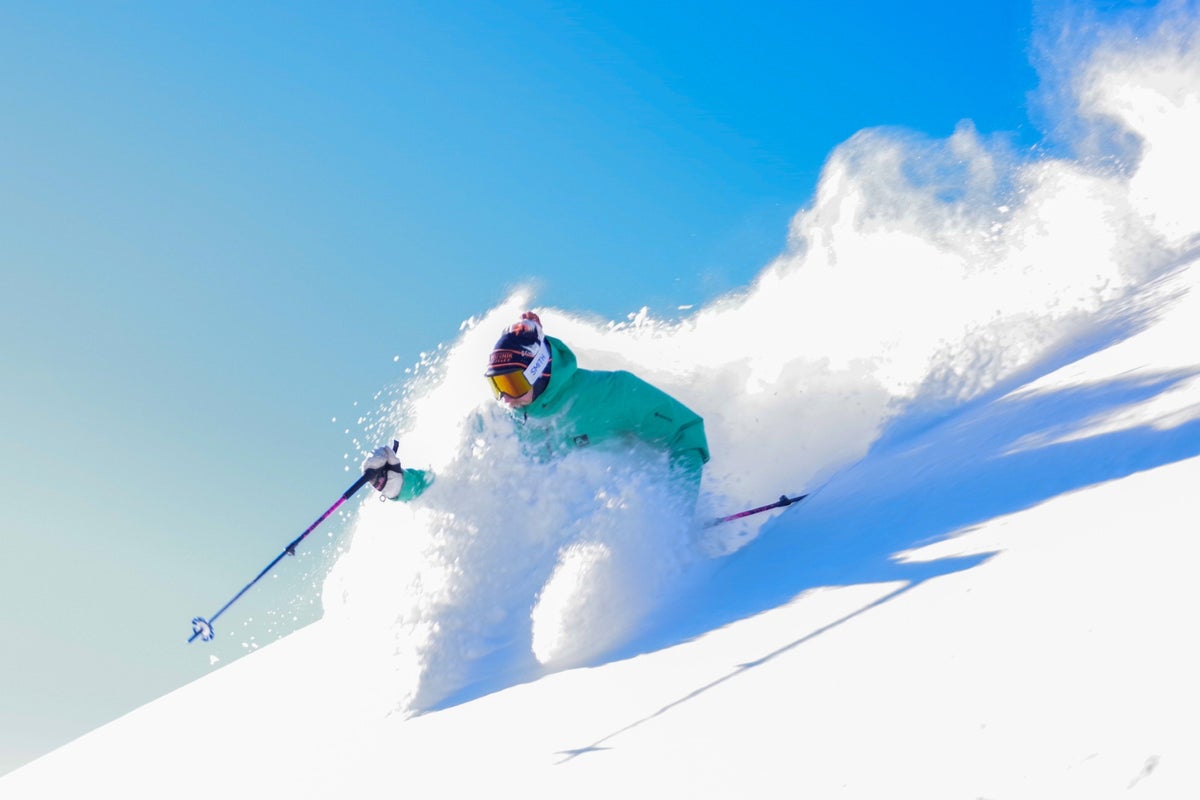 Person skiing through powder on a sunny day