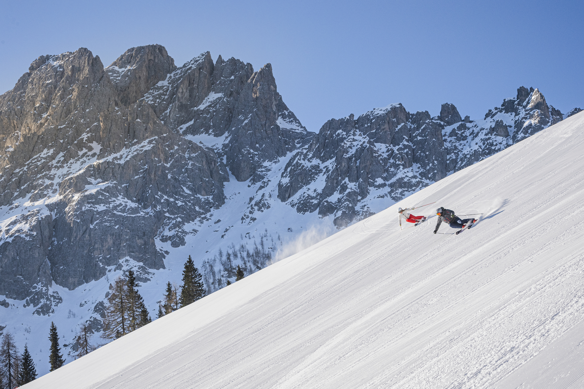 Two people skiing down run at 3 Zinnen Dolomites in Italy on a Sunny Day