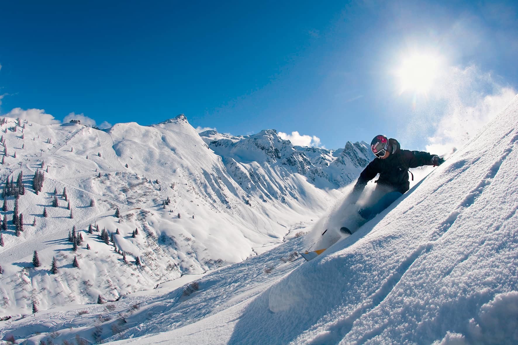 Snowboardista v prašane vo voľnom teréne v stredisku Silvretta Montafon