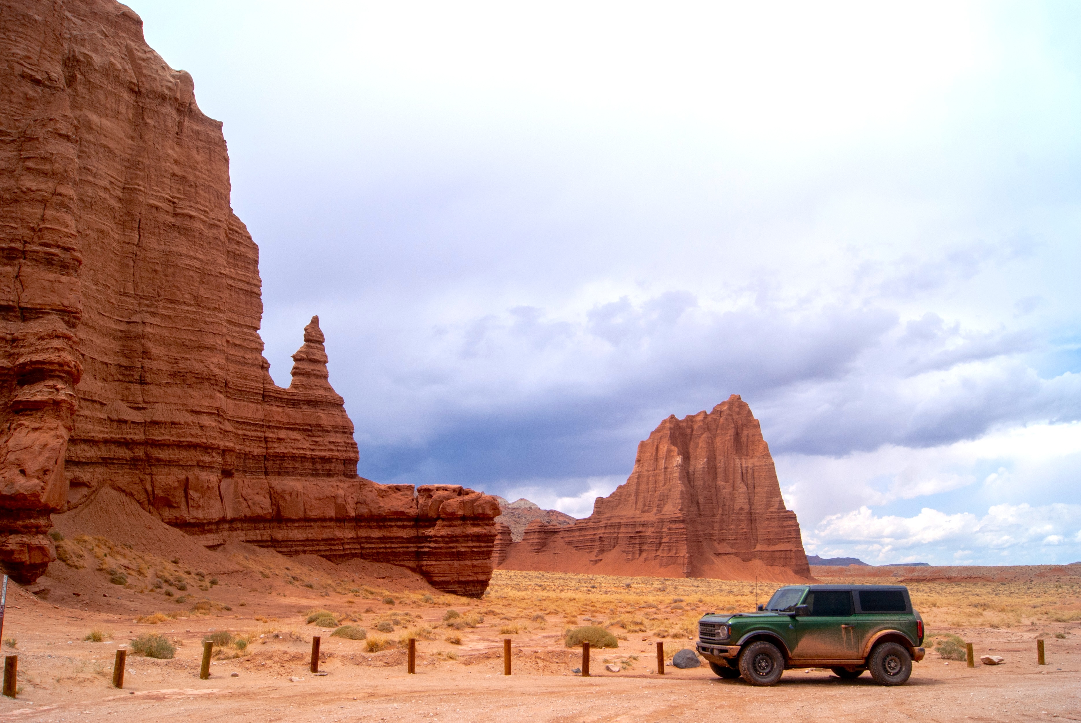 Car parked alongside large natural monument cathedrals on a cloudy day